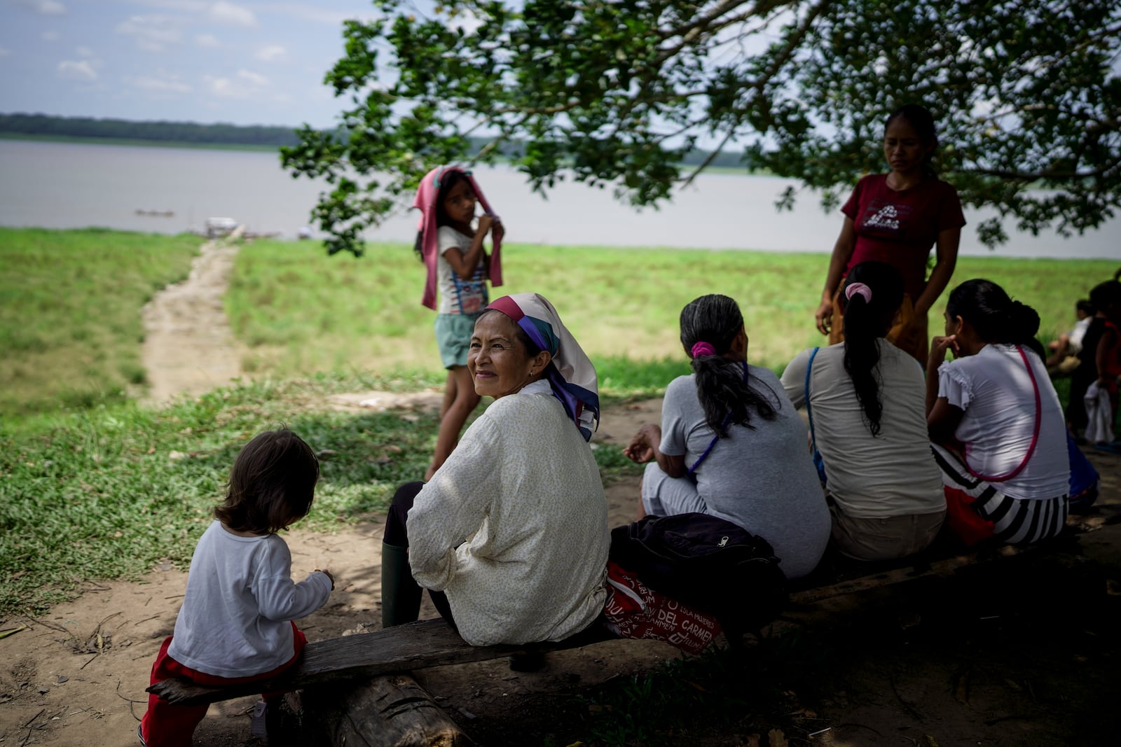 People from the Tikuna Indigenous community wait to receive aid from a nonprofit amid a drought on Amazon River in Loma Linda, near Leticia, Colombia, Sunday, Oct. 20, 2024. (AP Photo/Ivan Valencia)