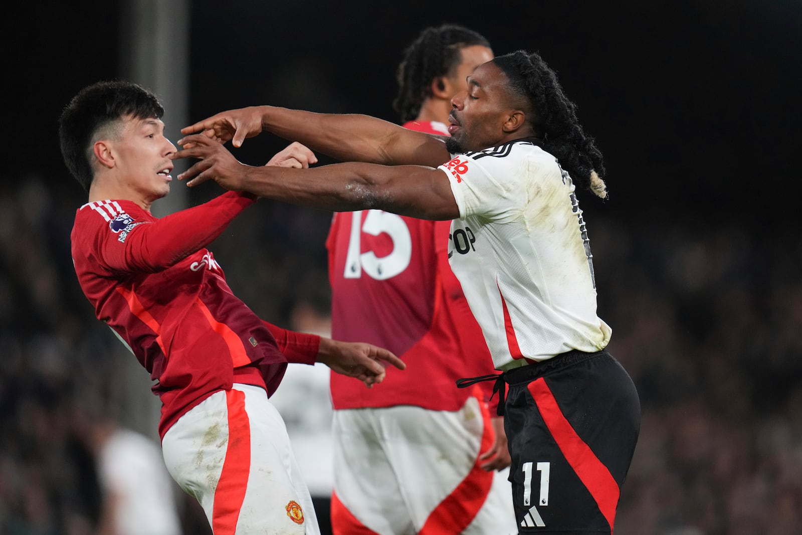 Fulham's Adama Traore, right, argues Manchester United's Lisandro Martinez during the English Premier League soccer match between Fulham and Manchester United at Craven Cottage stadium in London, Sunday, Jan. 26, 2025. (AP Photo/Kirsty Wigglesworth)