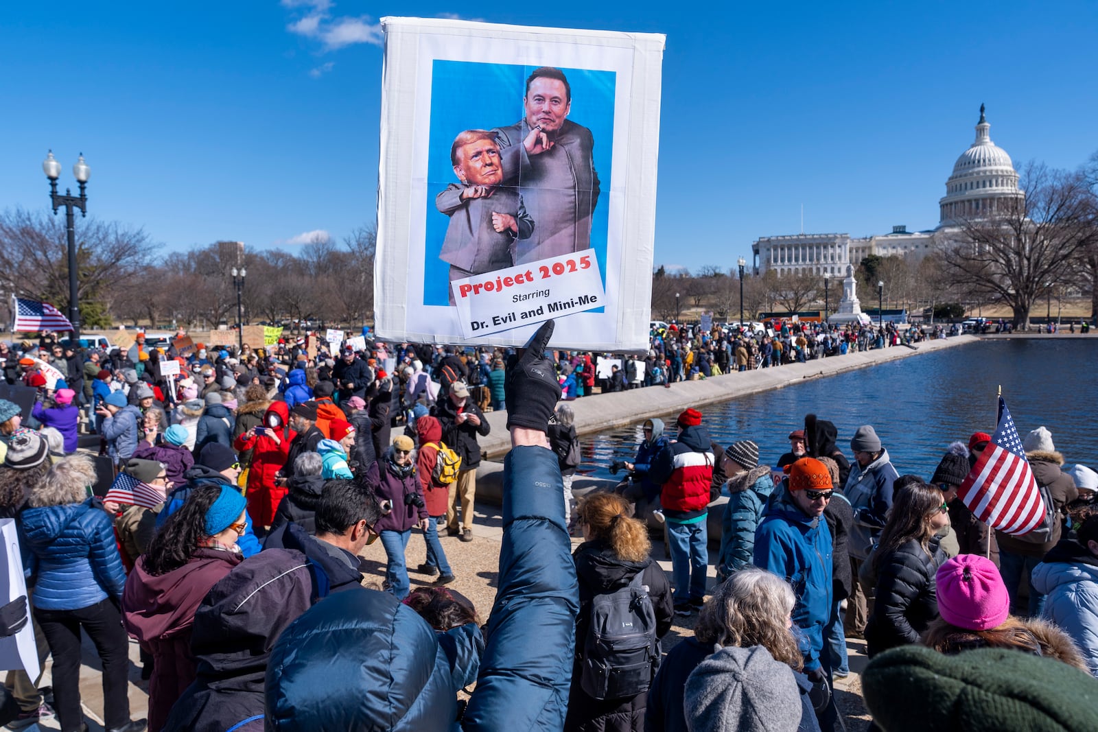 People protest as part of the “No Kings Day” protest on Presidents Day in Washington, in support of federal workers and against recent actions by President Donald Trump and Elon Musk, Monday, Feb. 17, 2025, by the Capitol in Washington. (AP Photo/Jacquelyn Martin)