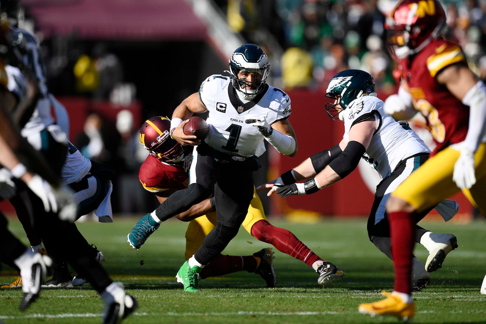 Philadelphia Eagles quarterback Jalen Hurts (1) scrambles as he carries the ball during the first half of an NFL football game against the Washington Commanders, Sunday, Dec. 22, 2024, in Landover, Md. (AP Photo/Nick Wass)