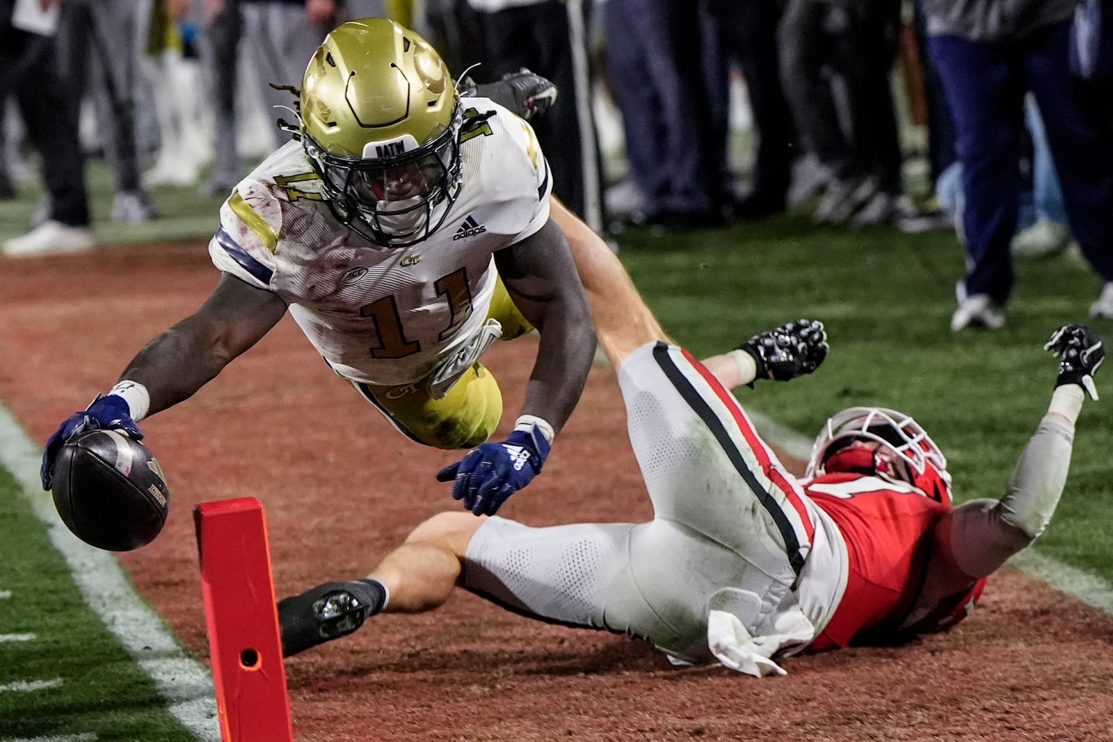 Georgia Tech running back Jamal Haynes (11) leaps into the end zone for a touchdown against Georgia defensive back Dan Jackson (17) during the first half of an NCAA college football game, Friday, Nov. 29, 2024, in Athens, Ga. (AP Photo/Mike Stewart)