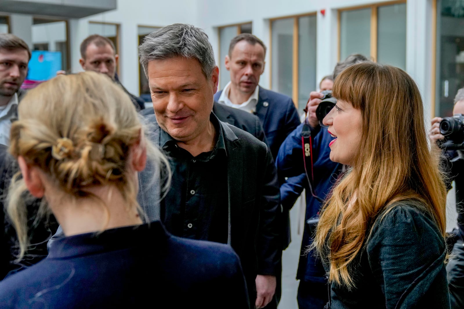 German Economy and Climate Minister and member of the Greens, Robert Habeck, center, talks to Ines Schwerdtner, left, co-leader of the Left Party (Die Linke), and Heidi Reichinnek, right, member of the German federal parliament and member of the Left Party (Die Linke), after a press a press conference of the Greens in Berlin, Germany, Monday, Feb. 24, 2025, the day after the national election. (AP Photo/Michael Probst)