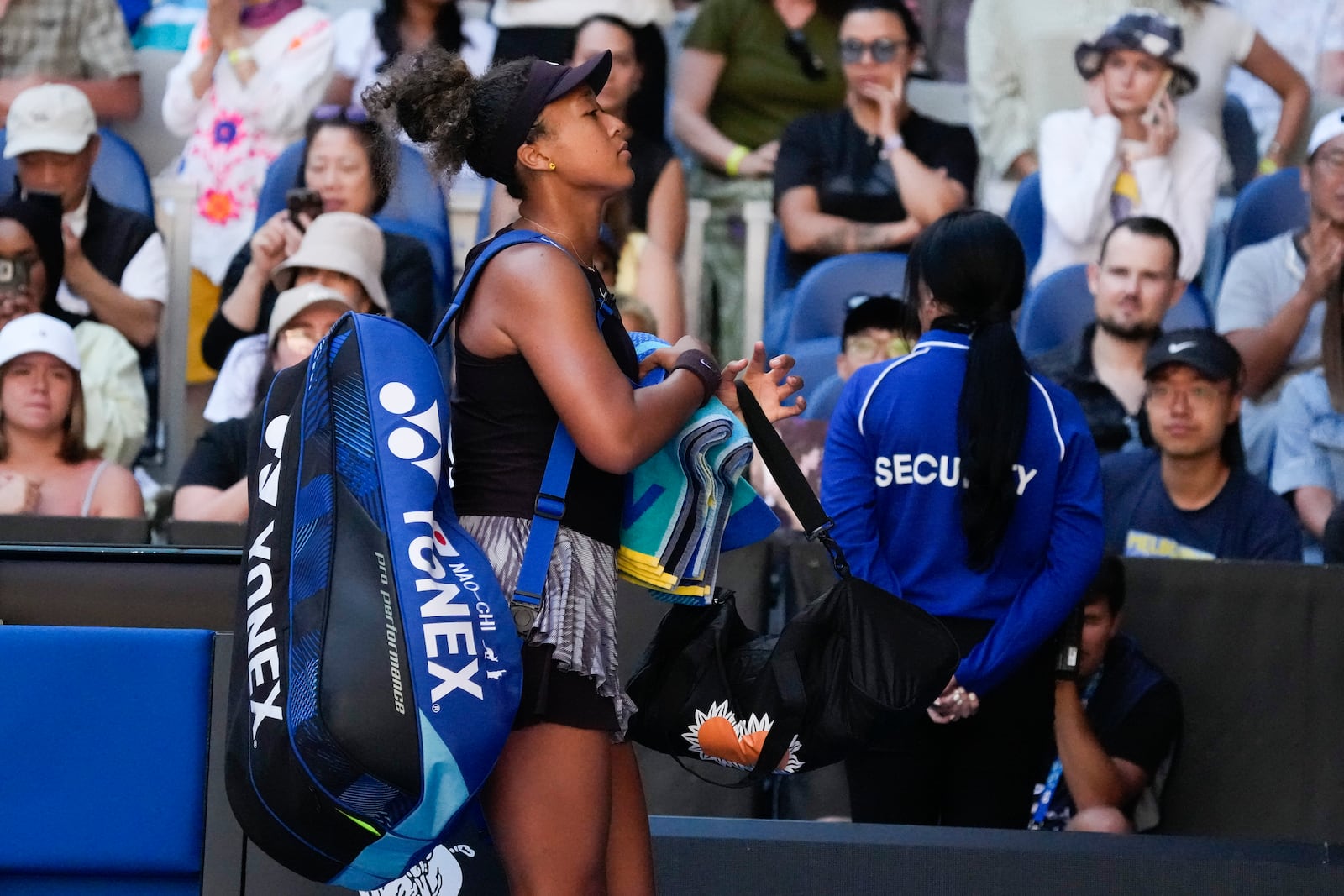 Naomi Osaka of Japan leaves the court after retiring from her third round match against Belinda Bencic of Switzerland at the Australian Open tennis championship in Melbourne, Australia, Friday, Jan. 17, 2025. (AP Photo/Manish Swarup)