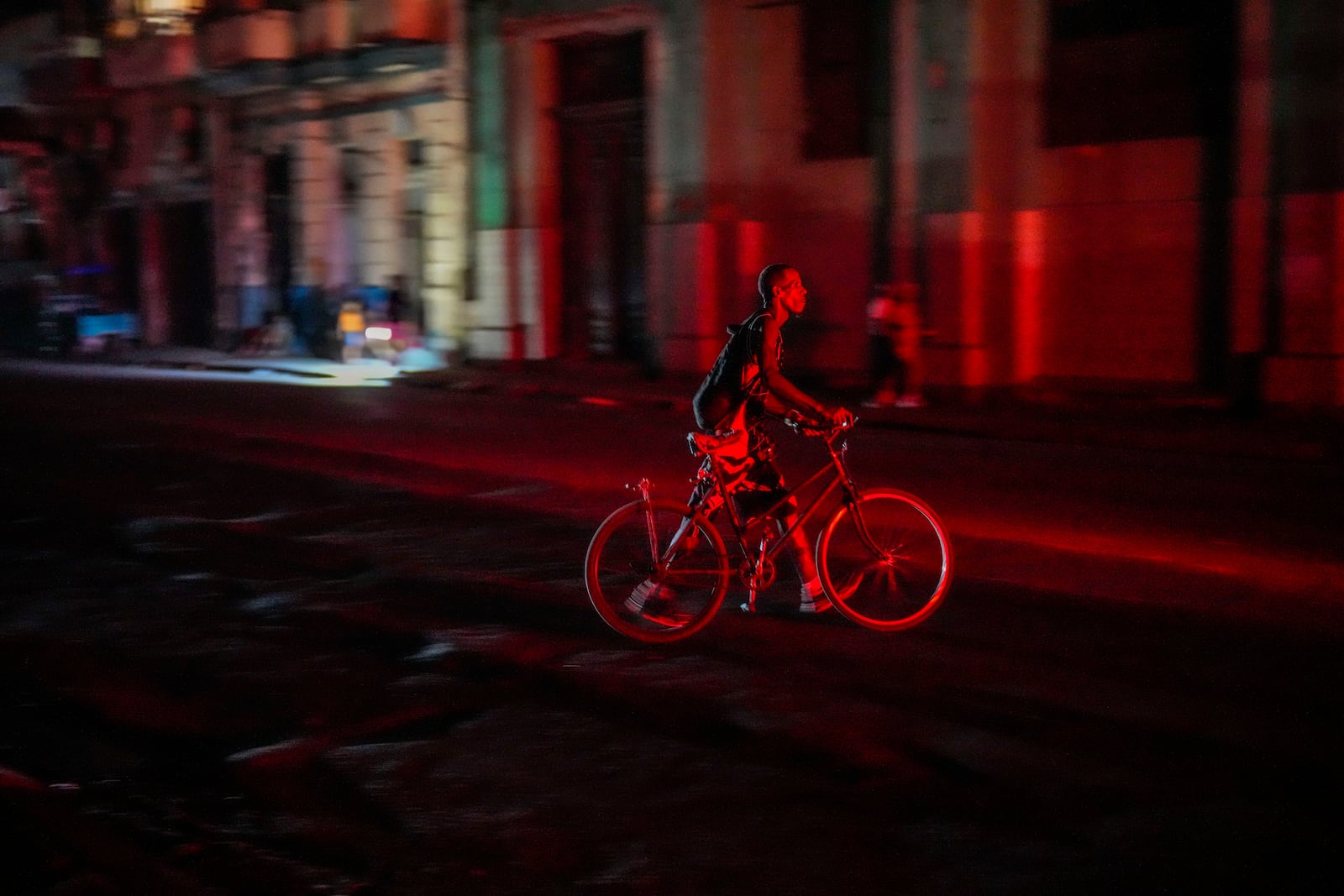 A resident walks his bicycle during a blackout following the failure of a major power plant in Havana, Cuba, Sunday, Oct. 20, 2024. (AP Photo/Ramon Espinosa)