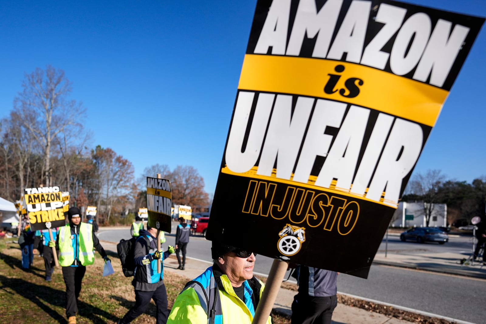 A pro-union demonstrator marches outside an Amazon warehouse, Friday, Dec. 20, 2024, in Alpharetta, Ga. (AP Photo/Mike Stewart)