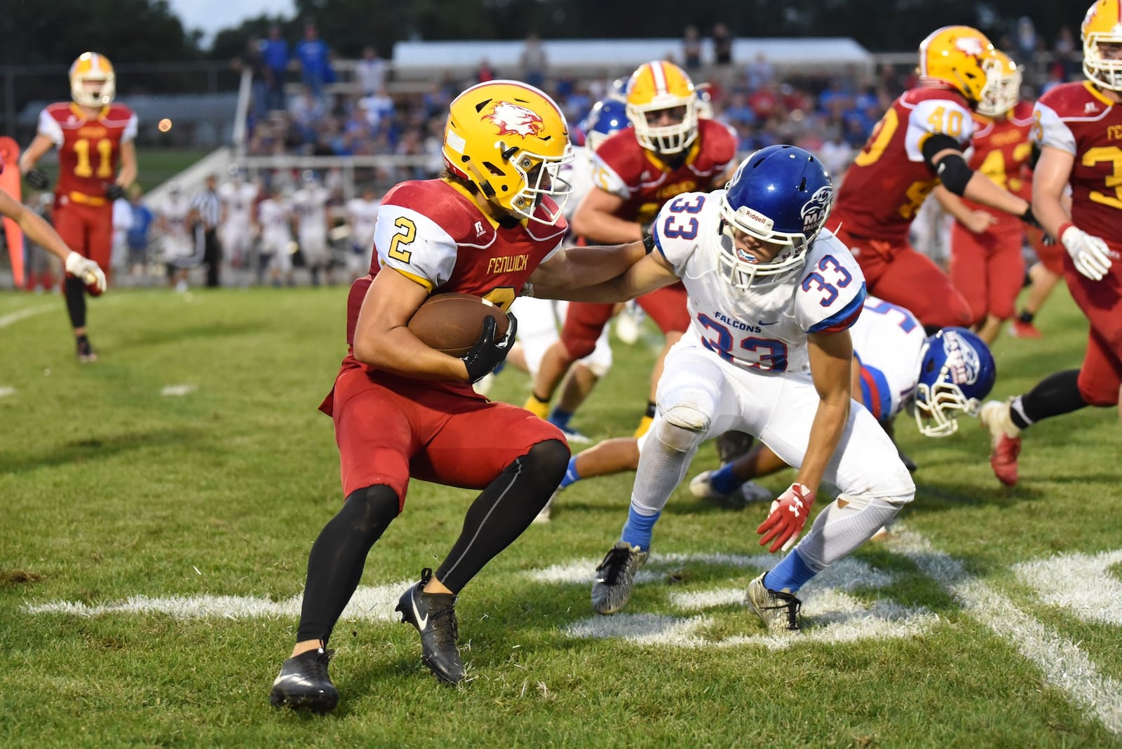 Fenwick’s R.J. Clesceri (2) is pursued by Clinton-Massie’s Robby Frederick (33) on Friday night at Krusling Field in Middletown. Massie posted a 21-18 victory. CONTRIBUTED PHOTO BY ANGIE MOHRHAUS