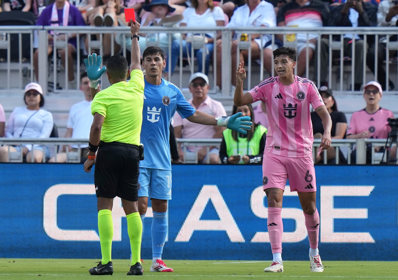 Inter Miami goalkeeper Oscar Ustari, center, is given a yellow card as midfielder Tomas Aviles (6) reacts during the first half of an MLS soccer match against Charlotte FC, Sunday, March 9, 2025, in Fort Lauderdale, Fla. (AP Photo/Lynne Sladky)