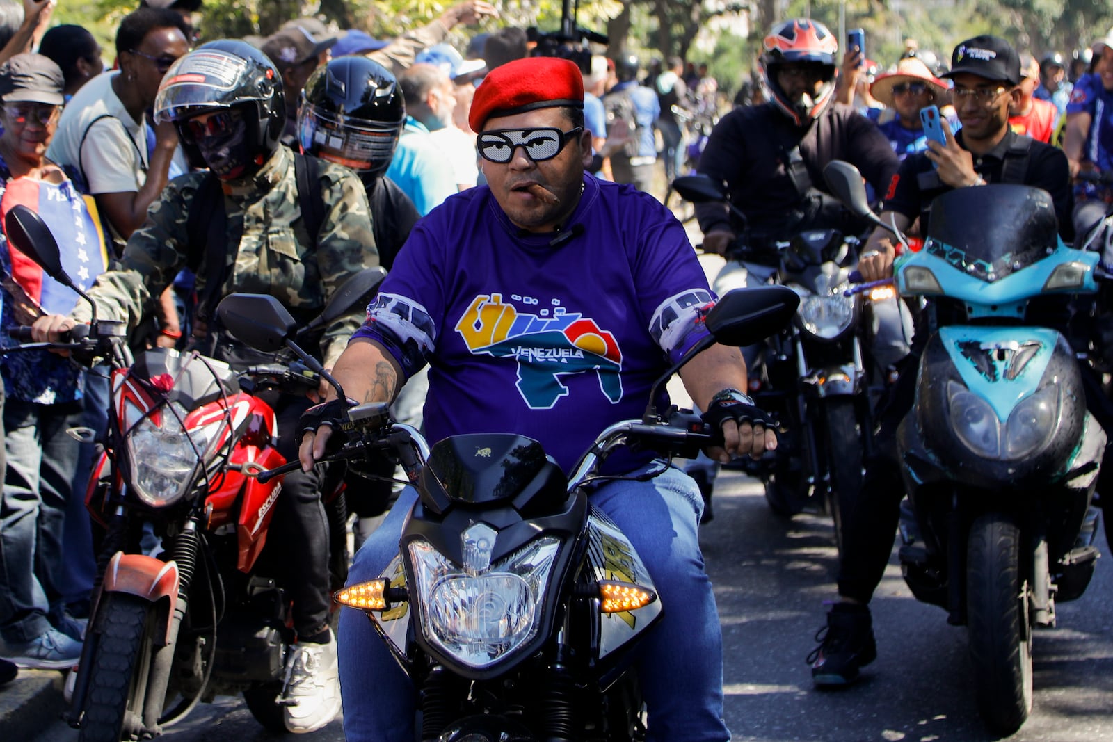 Government supporters ride past opponents of Venezuelan President Nicolas Maduro who are protesting the day before his inauguration for a third term in Caracas, Venezuela, Thursday, Jan. 9, 2025. (AP Photo/Cristian Hernandez)