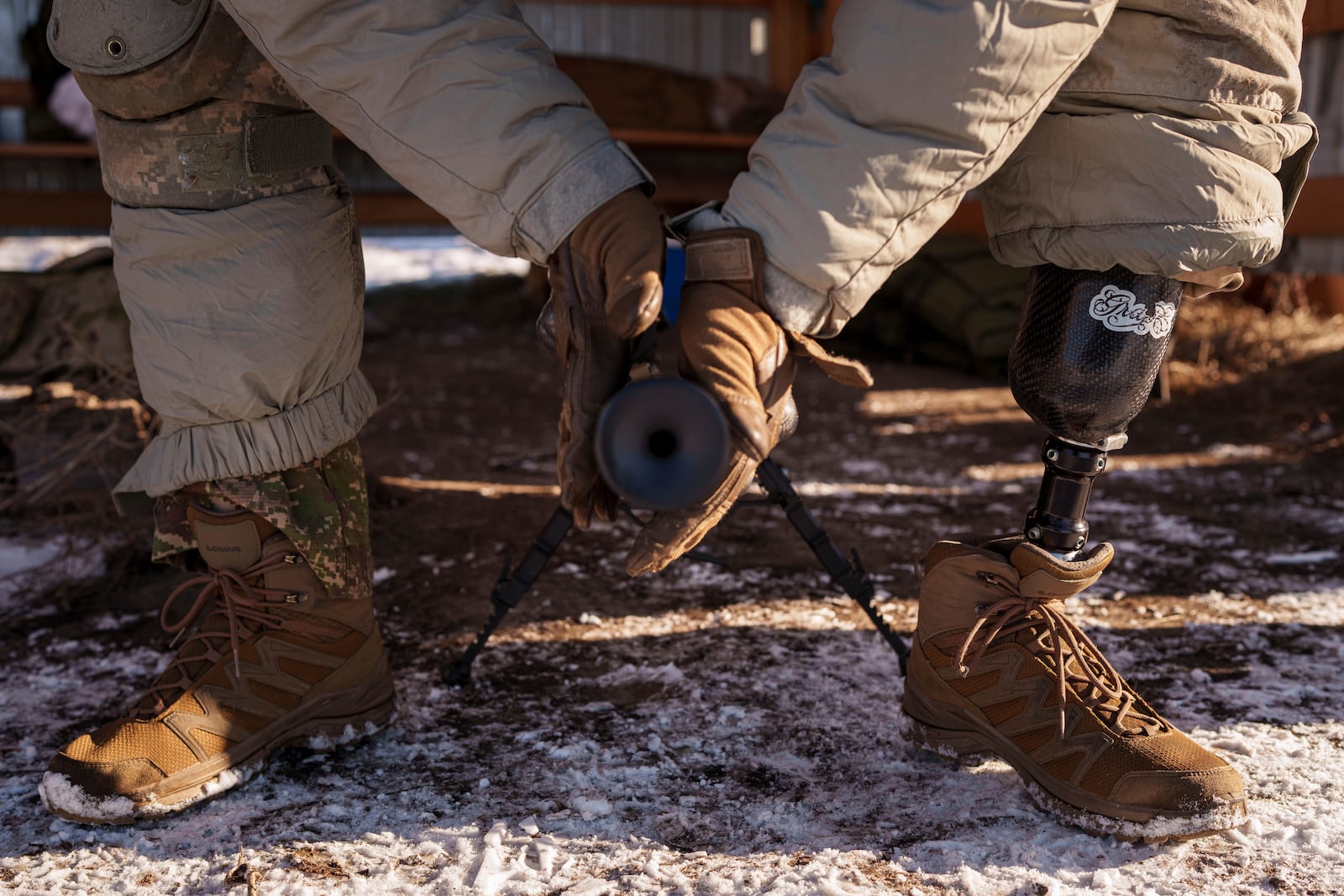 Serhii Pozniak, a commander with a Ukrainian sniper unit who lost a leg after stepping on a mine, mounts a suppressor on his rifle during military training near Kyiv, Ukraine, on Feb. 17, 2025. (AP Photo/Evgeniy Maloletka)