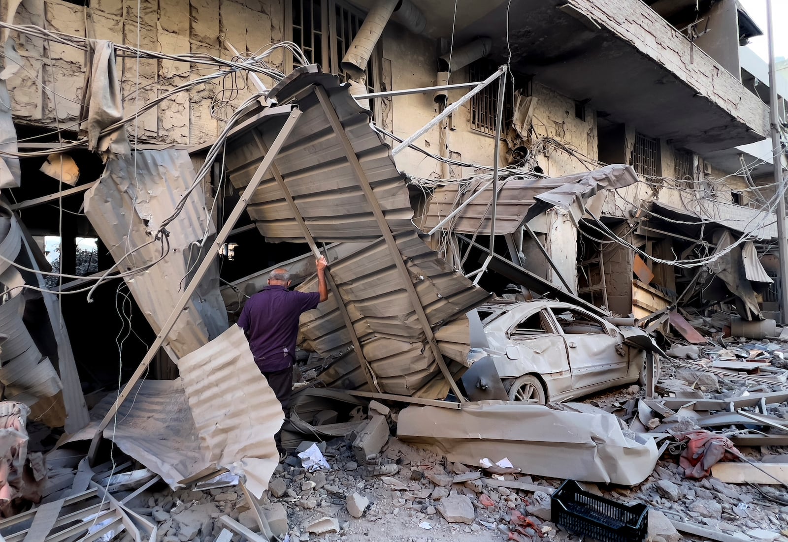 A man checks his destroyed shop at a street that was hit in an Israeli airstrike in Dahiyeh, in the southern suburb of Beirut, Lebanon, Thursday, Nov. 14, 2024. (AP Photo/Hussein Malla)