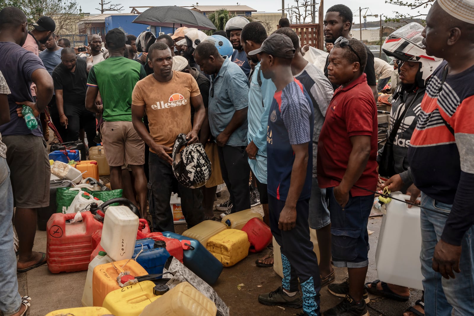 People queue for gas in Mamoudzou, in the French Indian Ocean island of Mayotte, Thursday, Dec. 19, 2024, after Cyclone Chido. (AP Photo/Adrienne Surprenant)