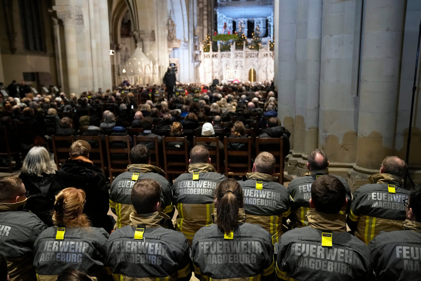 Firefighters, in the foreground, and others, attend a memorial service for victims of Friday's Christmas Market attack, where a car drove into a crowd, in Magdeburg, Germany, Saturday, Dec. 21, 2024. (AP Photo/Ebrahim Noroozi)