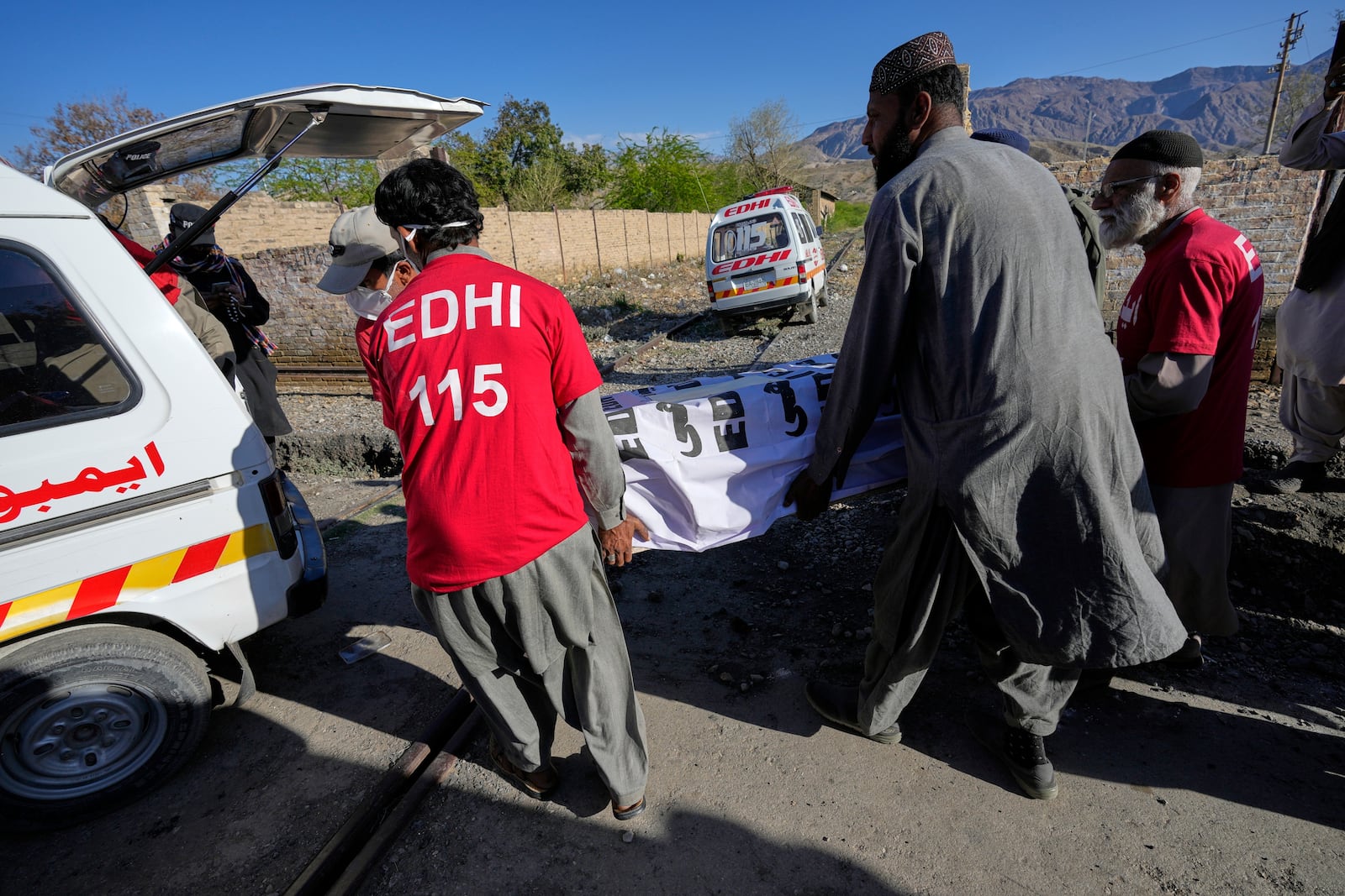 Rescue workers transport a coffin containing the body of a victim from a passenger train attacked by insurgents, upon arrival at a railway station in Much, Pakistan's southwestern Balochistan province, Thursday March 13, 2025. (AP Photo/Anjum Naveed)