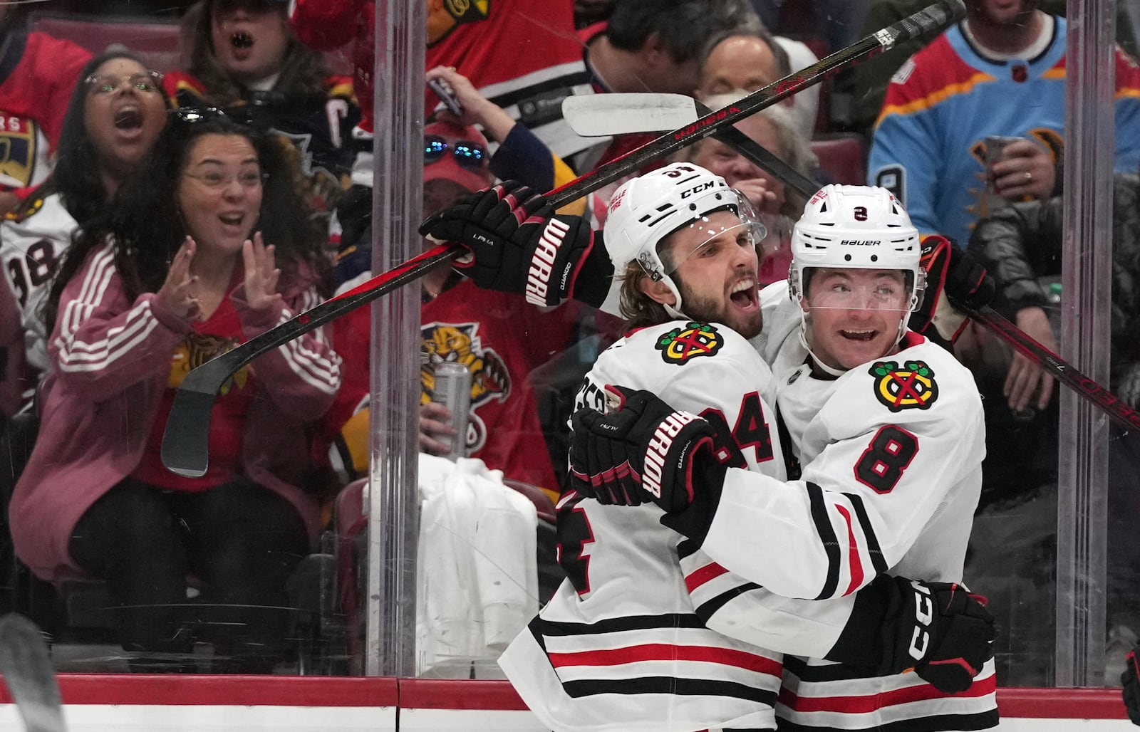 Chicago Blackhawks left wing Landon Slaggert, left, celebrates with center Ryan Donato (8) after scoring a goal during the first period of an NHL hockey game against the Florida Panthers, Saturday, Feb. 1, 2025, in Sunrise, Fla. (AP Photo/Lynne Sladky)