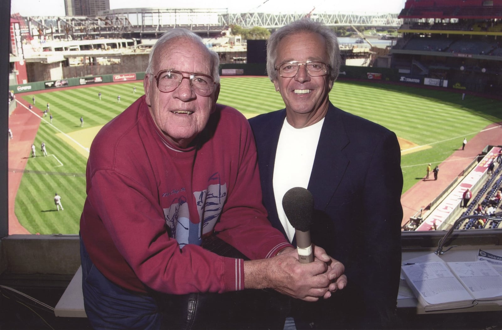 Joe Nuxhall and Marty Brennaman at Riverfront Stadium with Great American Ballpark being build in background. Photo courtesy the Nuxhall family.