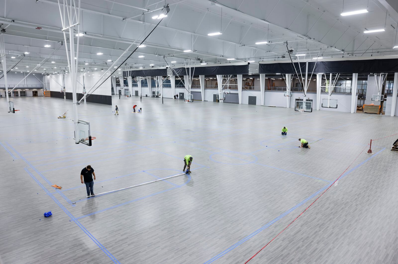 Crews are putting finishing touches on the hardwood and other courts at Spooky Nook sports Champion Mill. There are 14 hardwood basketball courts and 14 sports courts for a total of 28 basketball courts that can be converted to volleyball courts and other types of courts like pickleball, futsal or field hockey. Basketball and volleyball teams are already practicing at the facility. NICK GRAHAM/STAFF