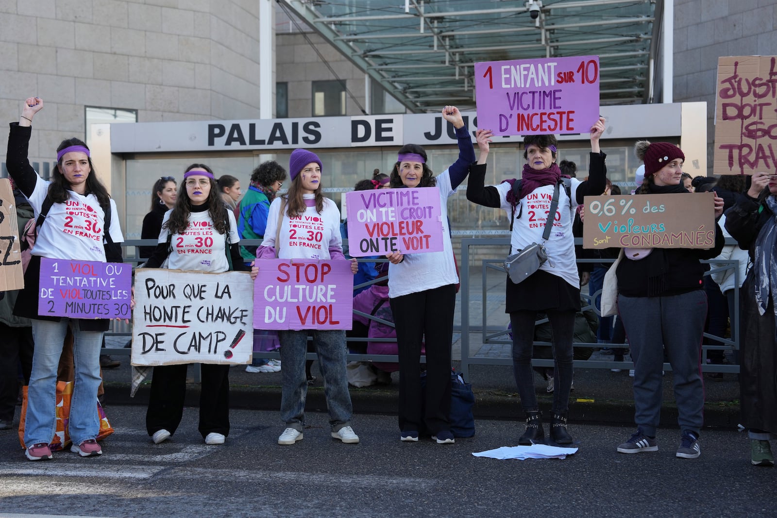 FILE - Activists hold posters in front of the Palace of Justice during a women's rights demonstration on Dec. 14, 2024, in Avignon, southern France, where the trial of dozens of men accused of raping Gisèle Pelicot while she was drugged and rendered unconscious by her husband is taking place. (AP Photo/Aurelien Morissard, File)