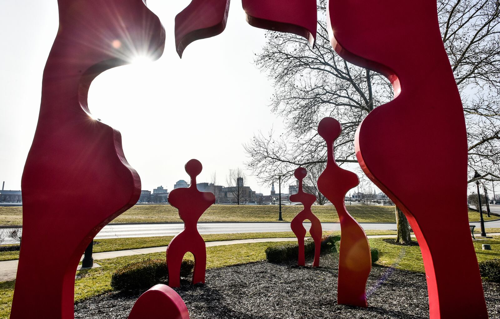 The "Family of Man" sculpture by Cynthia McKean is located at the park at the northwest corner of the High-Main Bridge.
This large, red steel sculpture represents mankind. It reminds us that we emerge from the Mother of all, Earth; and when our lives are finished, we return to her. It was created from one solid piece of steel and all the shapes fit like puzzle pieces, into that original form. Dedicated in November, 2009, this sculpture was donated in memory of Jean Wolfe, by the Wolfe family, with the help of City of Sculpture. NICK GRAHAM/STAFF