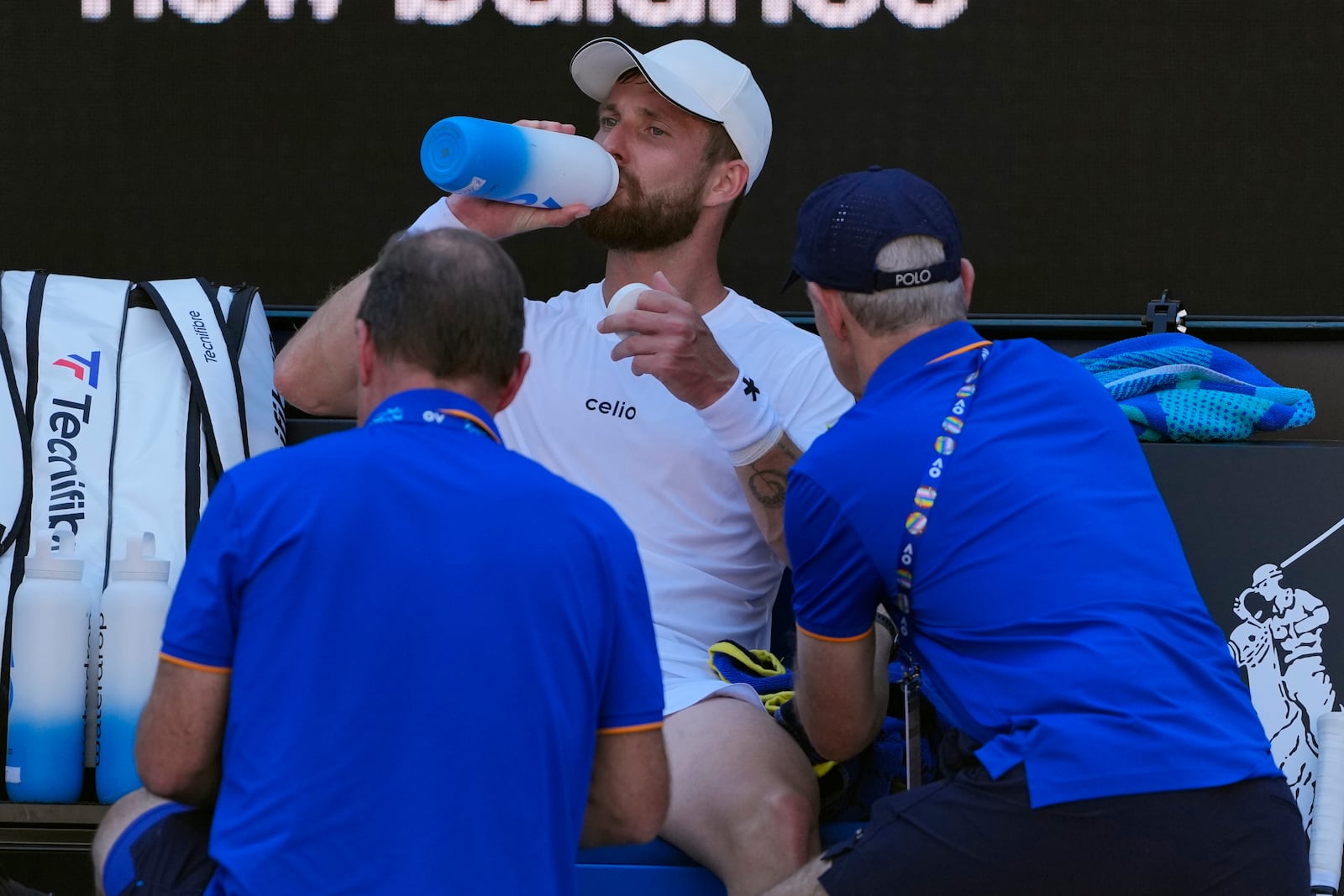 Corentin Moutet of France receives treatment from a trainer during his third round match against Learner Tien of the U.S. at the Australian Open tennis championship in Melbourne, Australia, Saturday, Jan. 18, 2025. (AP Photo/Vincent Thian)