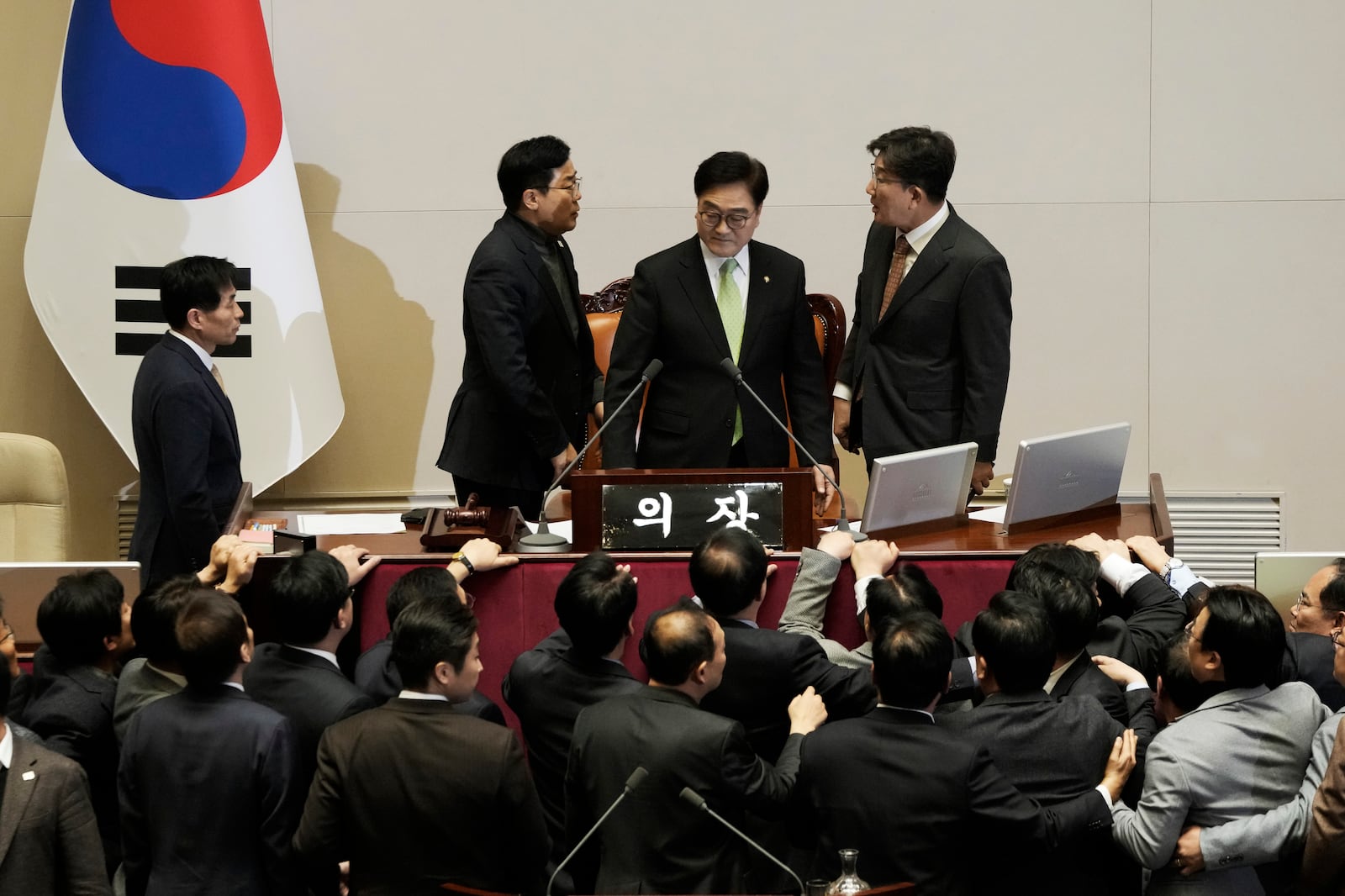 South Korea's ruling People Power Party floor leader Kweon Seong-dong, top right, argues with democratic Party floor leader Park Chan-dae, top left, as National Assembly Speaker Woo Won Shik stands between them during a plenary session for the impeachment motion against South Korean acting President Han Duck-soo at the National Assembly in Seoul, South Korea, Dec. 27, 2024. (AP Photo/Ahn Young-joon)