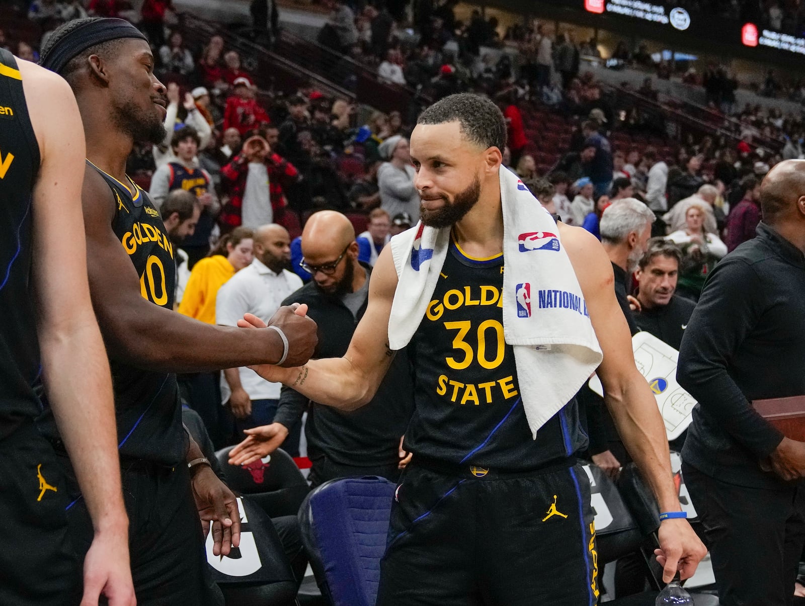 Golden State Warriors forward Jimmy Butler (10) and guard Stephen Curry (30) shake hands after an NBA basketball game against the Chicago Bulls, Saturday, Feb. 8, 2025, in Chicago. (AP Photo/Erin Hooley)