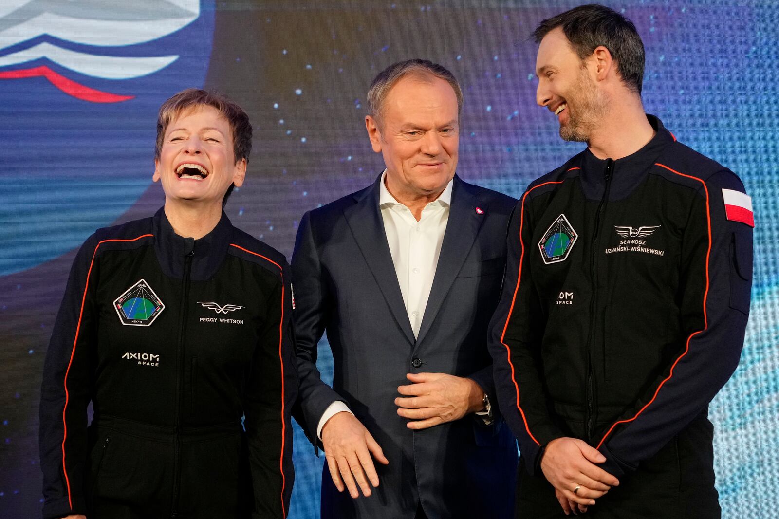 U.S. astronaut Peggy Whitson, commander of the Ax-4 space mission, left, Poland's Prime Minister Donald Tusk, center, and Polish member of the mission crew, astronaut Slawosz Uznanski-Wisniewski, right, pose during a media event dedicated to the preparations for the mission, at the Copernicus Science Center in Warsaw, Poland, Wednesday, Feb. 5, 2025. (AP Photo/Czarek Sokolowski)