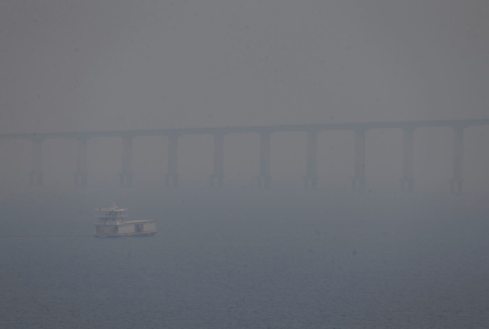 FILE - A boat navigates the Negro River amid smoke from wildfires in Manaus, Amazonas state, Brazil, Aug. 27, 2024. (AP Photo/Edmar Barros, File)