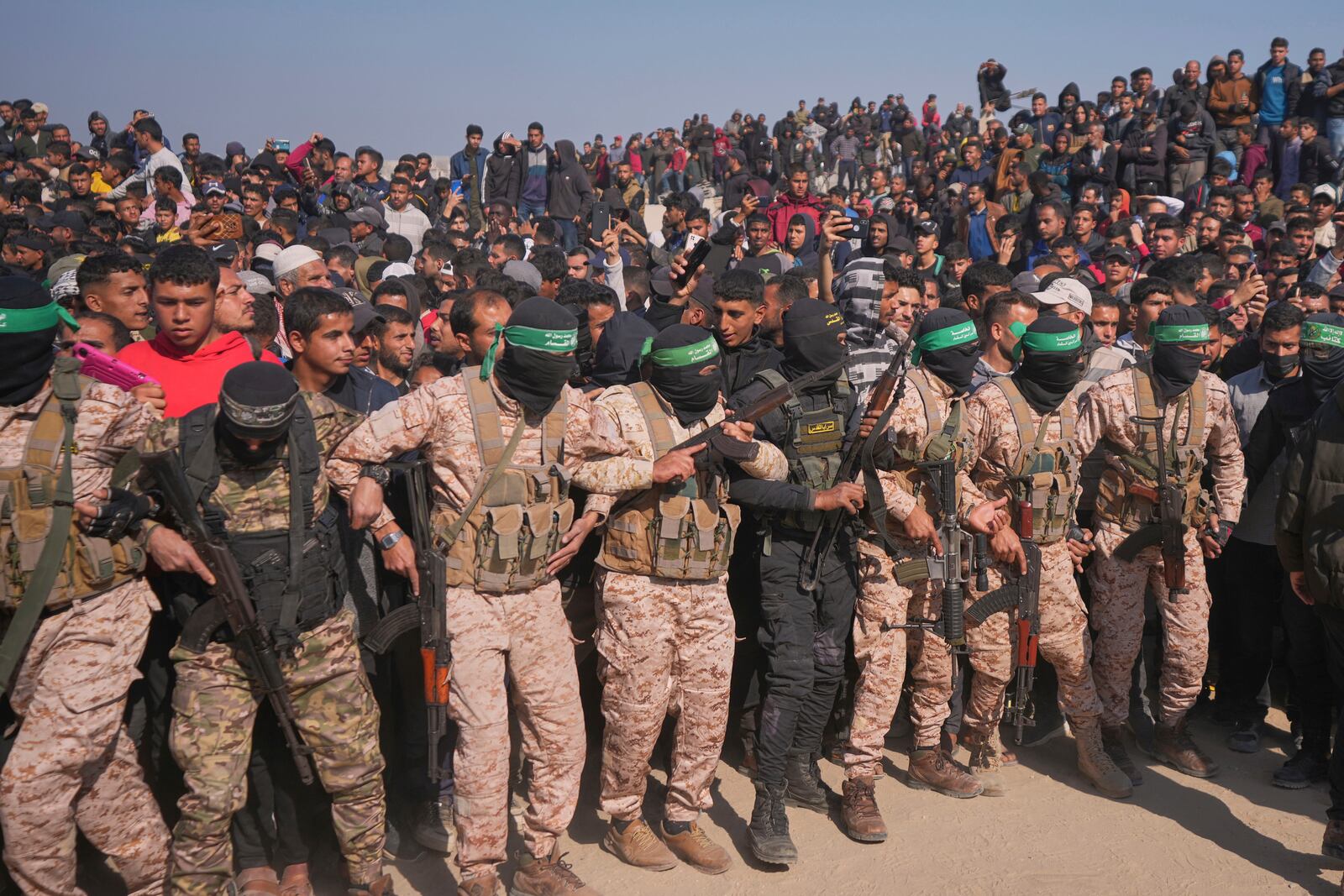 Hamas and Islamic Jihad fighters contain the crowd as cars carrying Israeli Gadi Mozes and Arbel Yahoud, who have been held hostages by Hamas in Gaza since October 7, 2023, are escorted to be handed over to the Red Cross in Khan Younis, southern Gaza Strip, Thursday Jan. 30, 2025.(AP Photo/Abdel Kareem Hana)