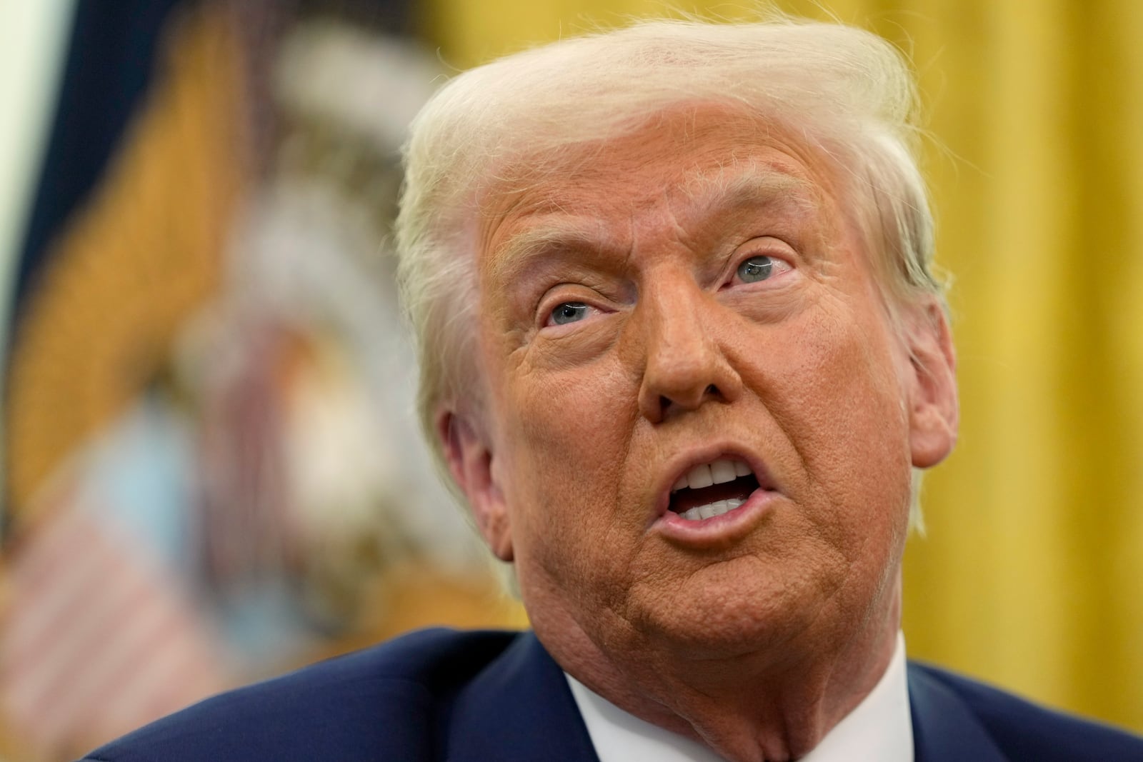 President Donald Trump speaks to reporters after signing an executive order in the Oval Office of the White House, Thursday, Feb. 13, 2025, in Washington. (AP Photo/Ben Curtis)