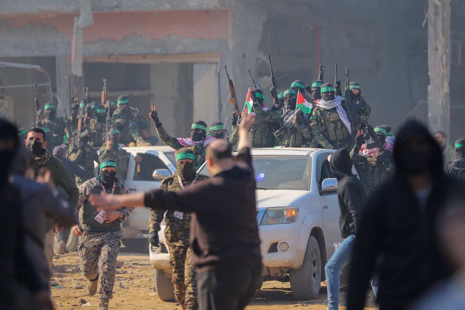 Hamas fighters are greeted as they arrive in pick-up trucks to the site of the hand over of hostage Agam Beger to the Red Cross at the Jabalya refugee camp in Gaza City, Thursday Jan. 30, 2025.(AP Photo/Mohammed Hajjar)