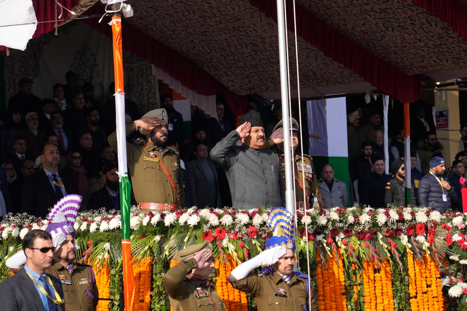 Deputy Chief Minister of Jammu and Kashmir Surinder Choudhary, center, salutes as an Indian national flag is hoisted during India's Republic Day parade in Srinagar, Indian controlled Kashmir, Sunday, Jan. 26, 2025. (AP Photo/Mukhtar Khan)