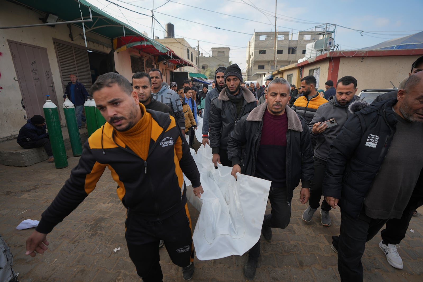 Mourners carry the bodies of three members of Imad Al-deen family who were killed in the Israeli bombardment in Bureij, central Gaza Strip, at Al-Aqsa Martyrs Hospital in Deir al-Balah, Monday, Jan. 6, 2025. (AP Photo/Abdel Kareem Hana)