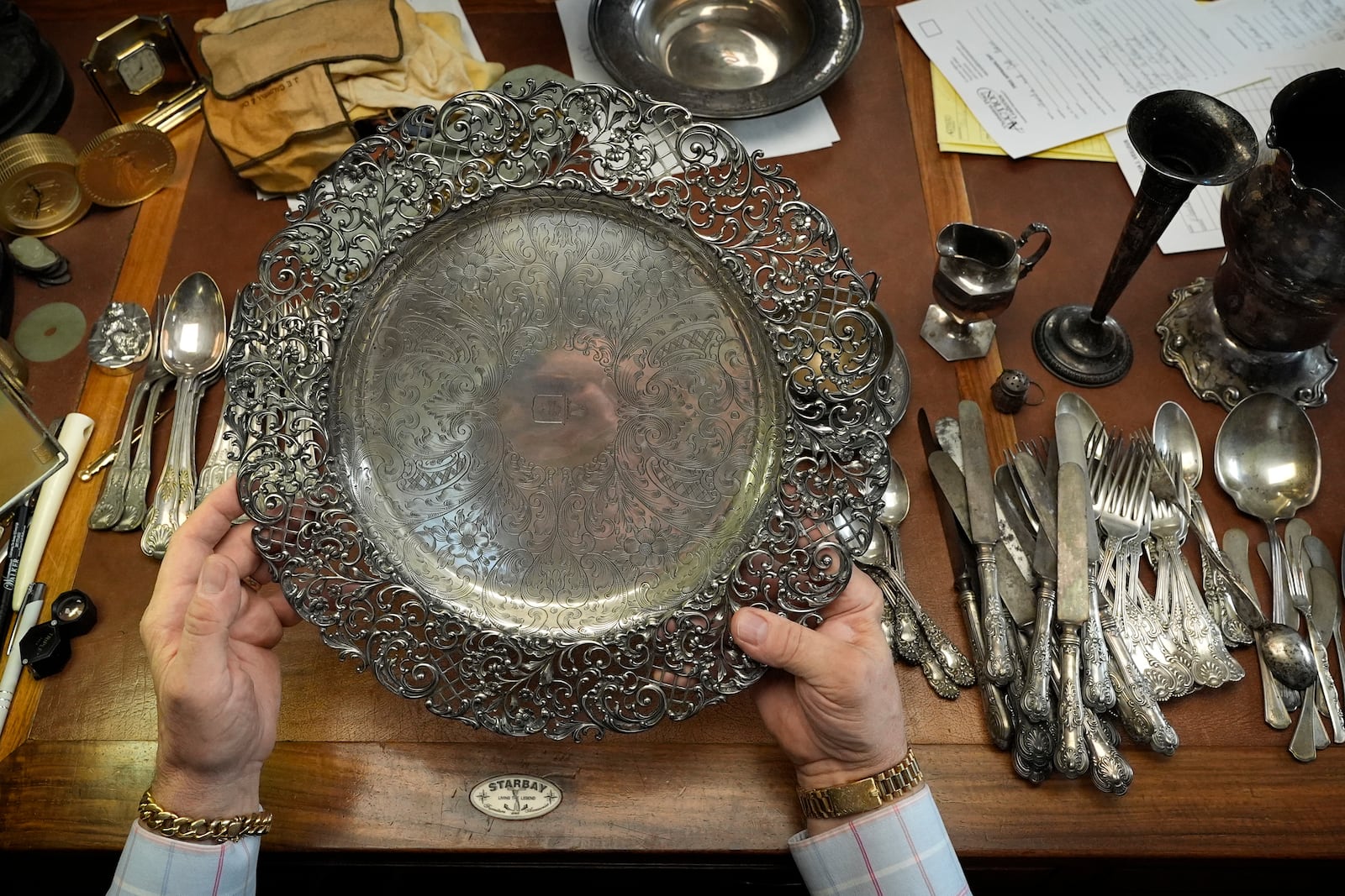 Appraiser Kaja Veilleux looks through a collection of silver items at Thomaston Place Auction Galleries, Tuesday, Nov. 19, 2024, in Thomaston, Maine. (AP Photo/Robert F. Bukaty)