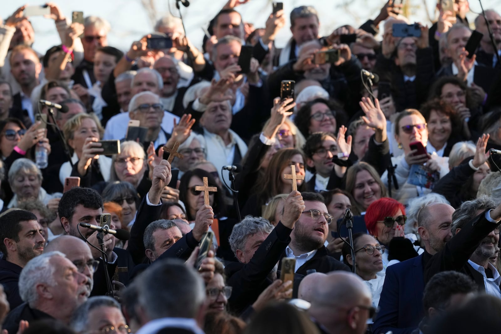 Faithful wait for the start of a mass celebrated by Pope Francis in Ajaccio "Place d'Austerlitz" during his visit in the French island of Corsica, Sunday, Dec. 15, 2024. (AP Photo/Alessandra Tarantino)