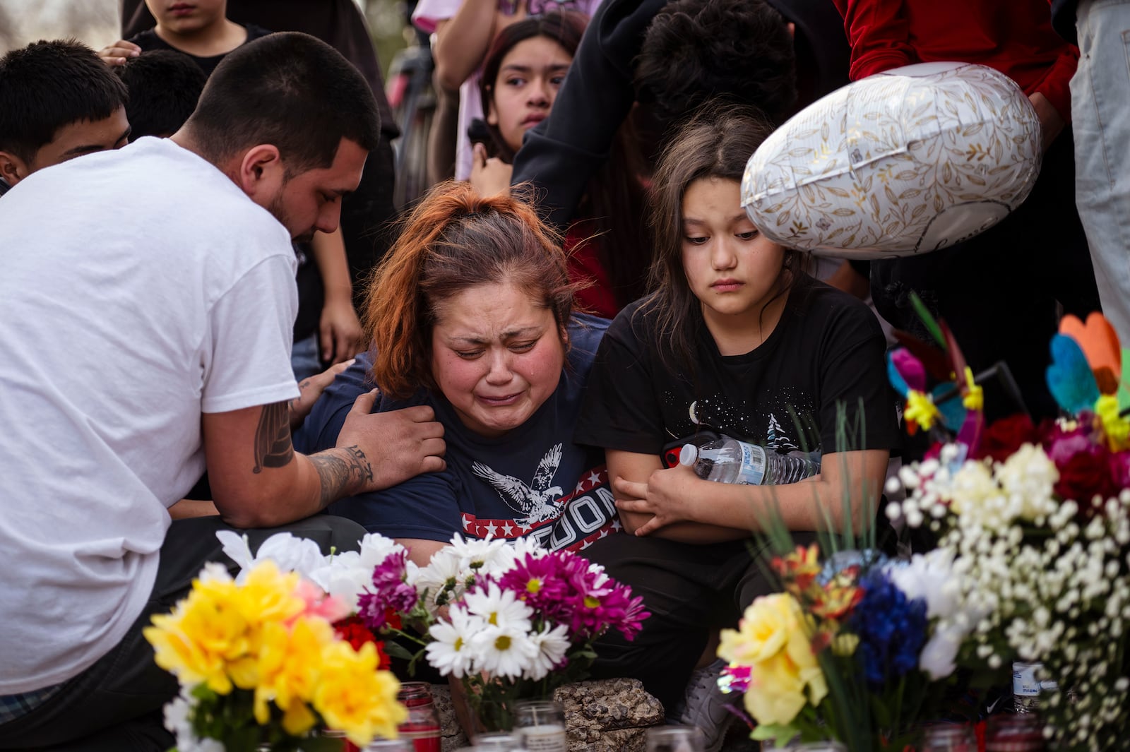 Family members of 17-year-old victim Jason Gomez mourn during a vigil at Young Park in Las Cruces, N.M., on Sunday, March 23, 2025. (Chancey Bush/The Albuquerque Journal via AP)