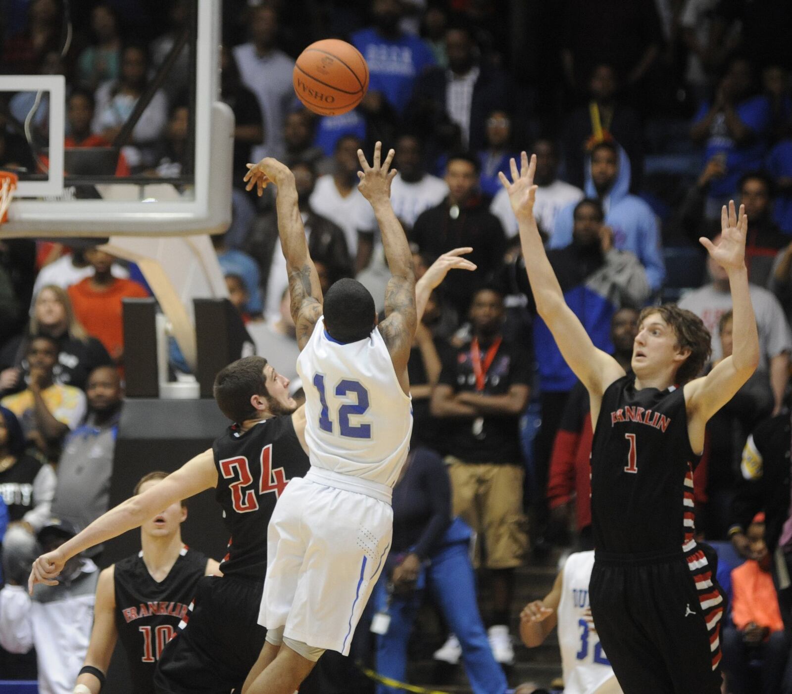 Dunbar’s Amos “A.J.” Harris (12) launches a shot over Matt Thompson (24) and Austin Doliboa (1) of Franklin during a Division II regional final at the University of Dayton Arena on March 21, 2015. MARC PENDLETON/STAFF