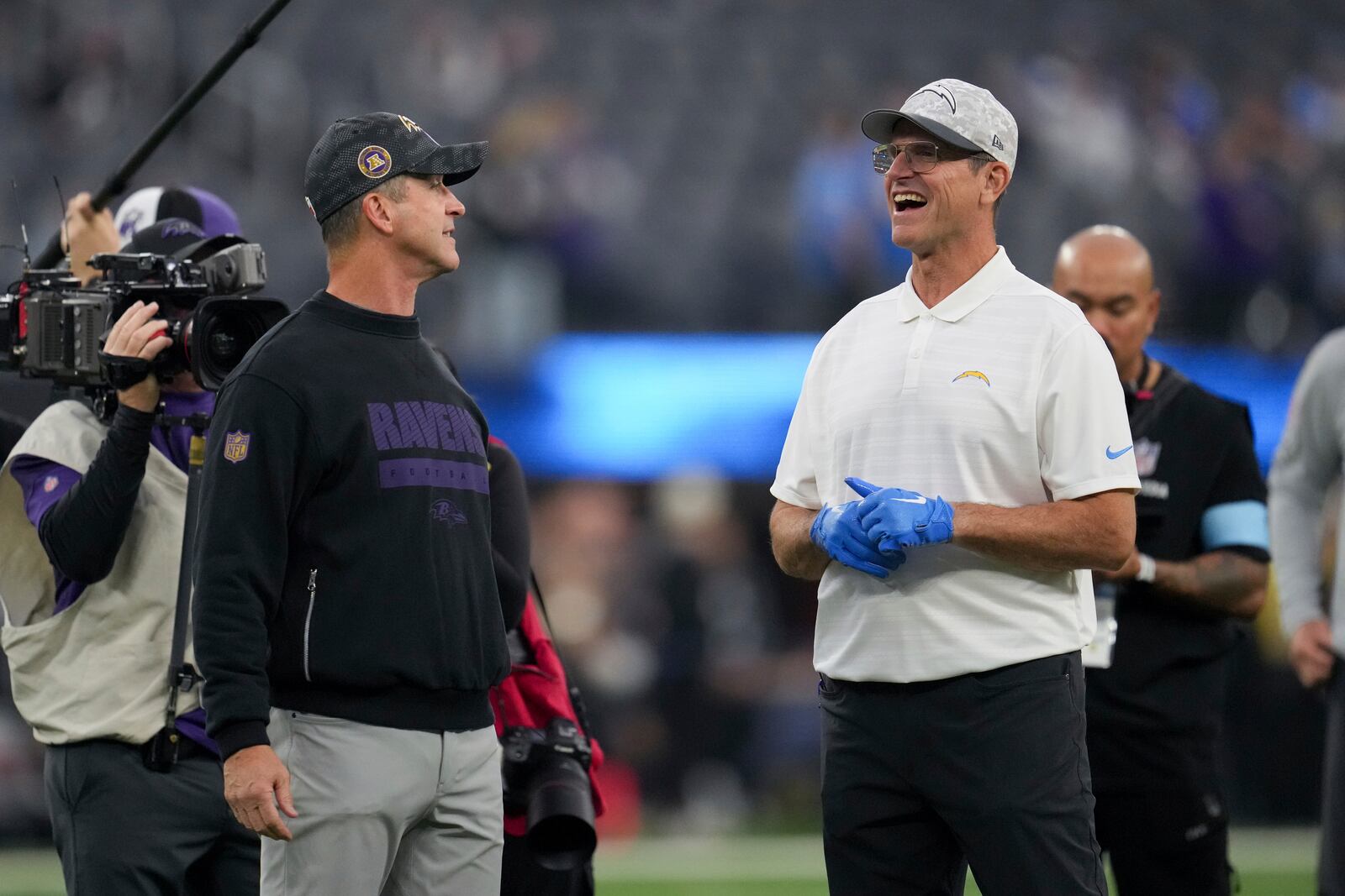 Los Angeles Chargers head coach Jim Harbaugh, right, talks to his brother, Baltimore Ravens Head Coach John Harbaugh, before an NFL football game Monday, Nov. 25, 2024, in Inglewood, Calif. (AP Photo/Eric Thayer)