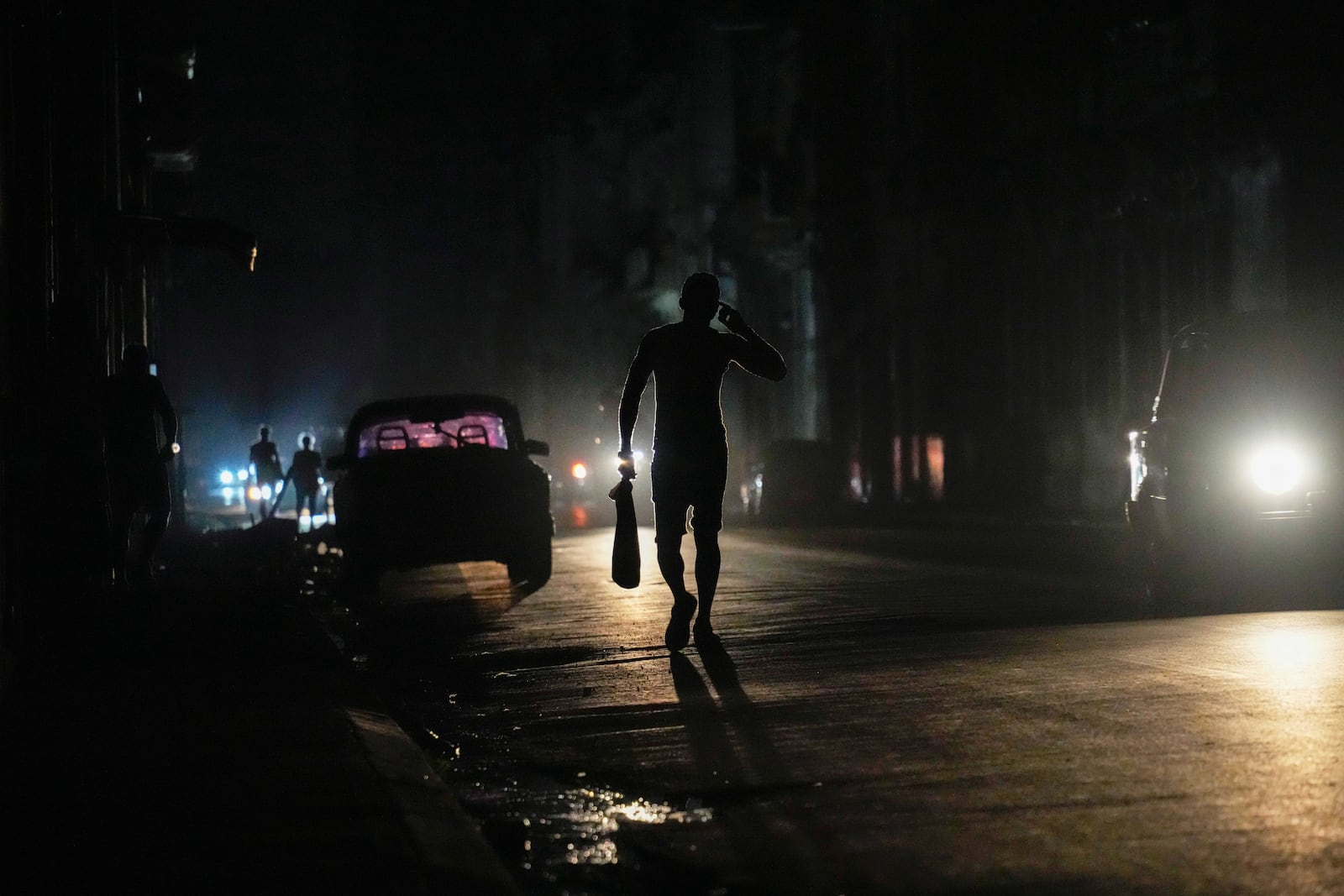 A resident walks on a street during a general blackout in Havana, Cuba, Friday, March 14, 2025. (AP Photo/Ramon Espinosa)