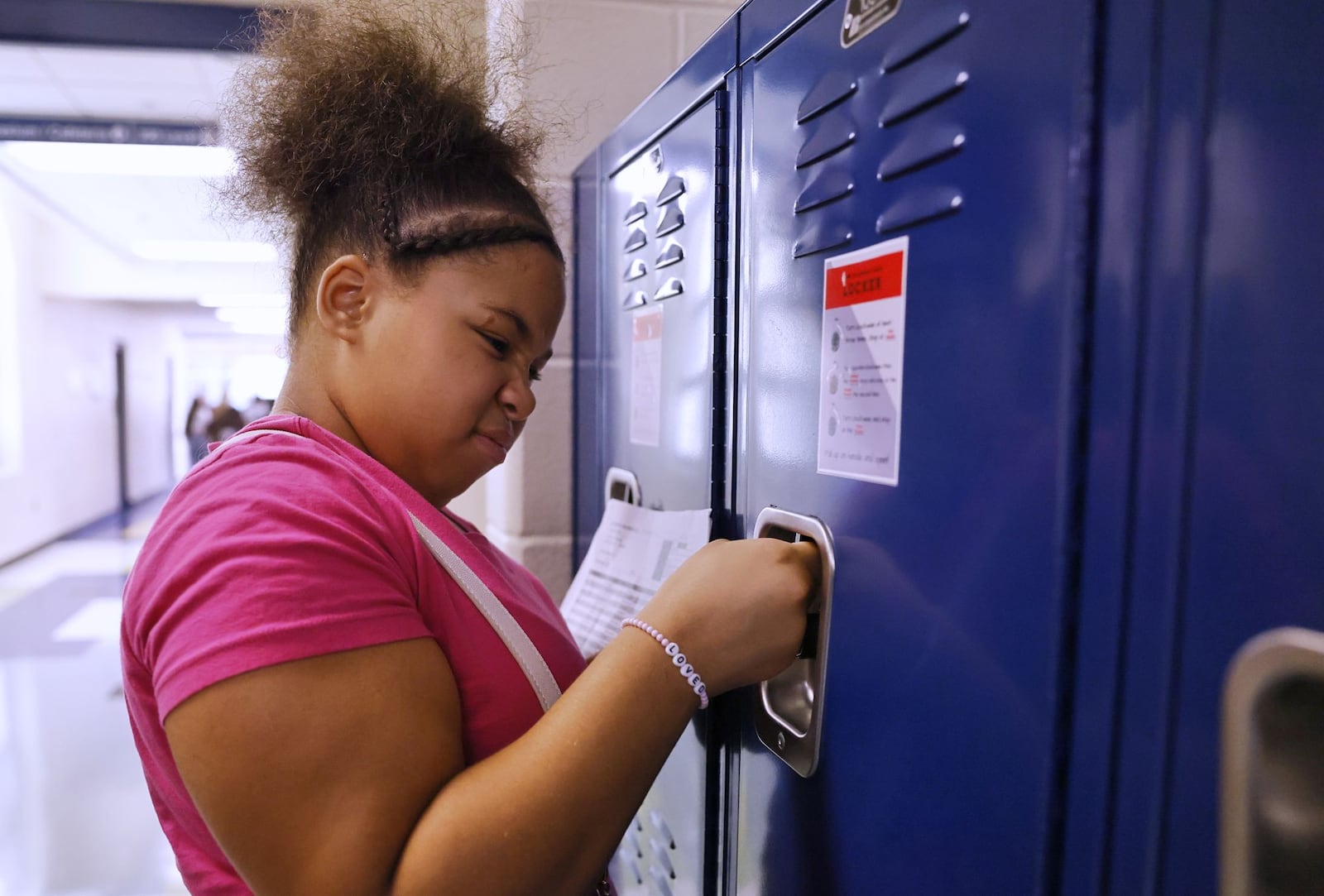 Braniya England, 13, makes a face in frustration as she tries to open her locker during an open house Wednesday, Aug. 7, 3024 at Wilson Middie School in Hamilton. NICK GRAHAM/STAFF