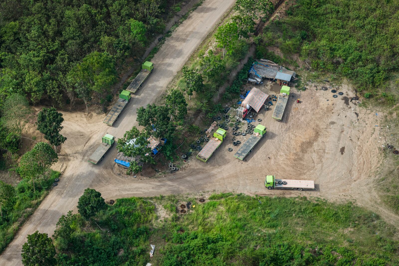 Trucks are parked near a road leading to areas of wood pellet production companies in Pohuwato, Gorontalo province, Indonesia, Tuesday, Oct. 22, 2024. (AP Photo/Yegar Sahaduta Mangiri)