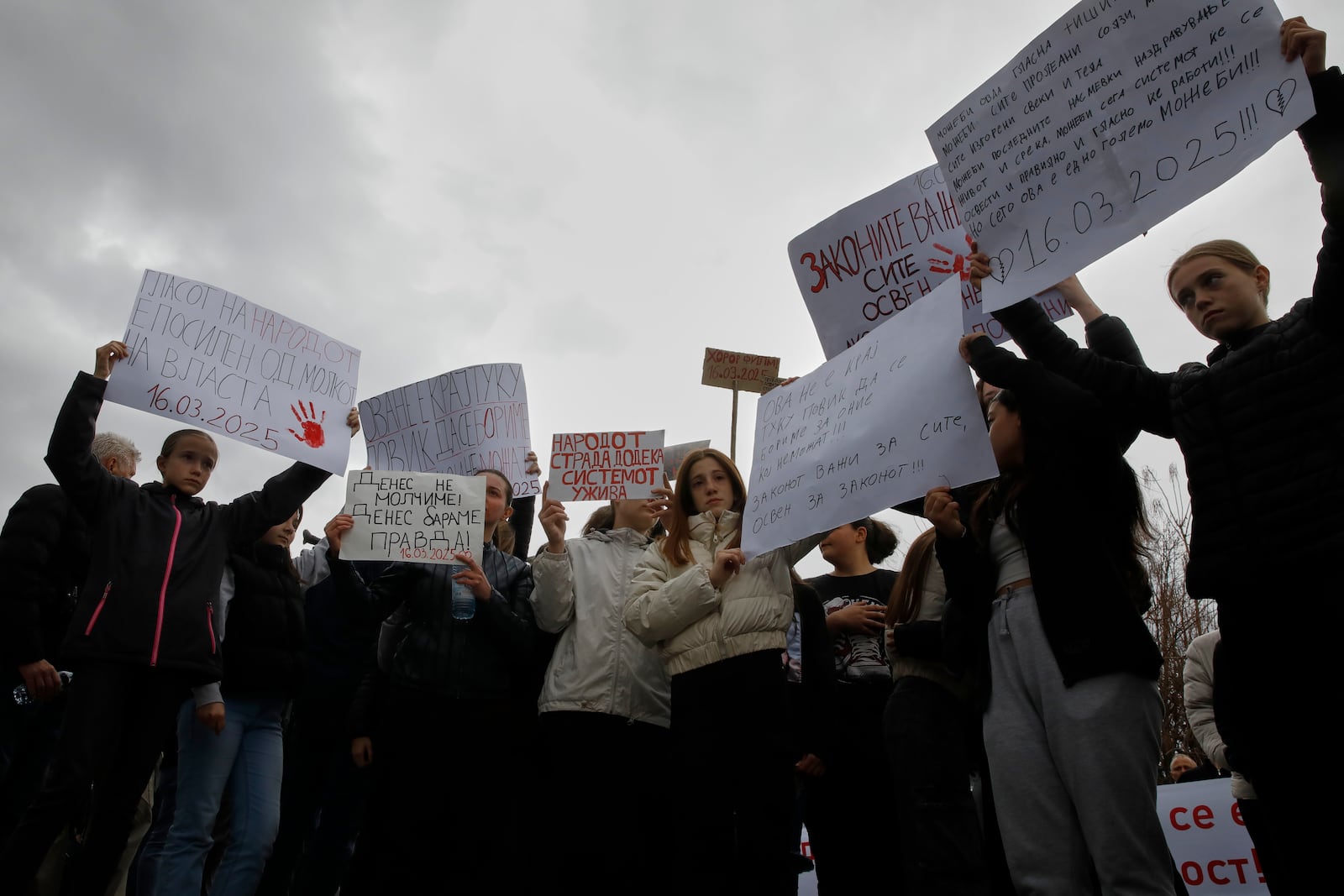 Protesters hold placards during a protest following a massive nightclub fire in the town of Kocani, North Macedonia, Monday, March 17, 2025. (AP Photo/Boris Grdanoski)