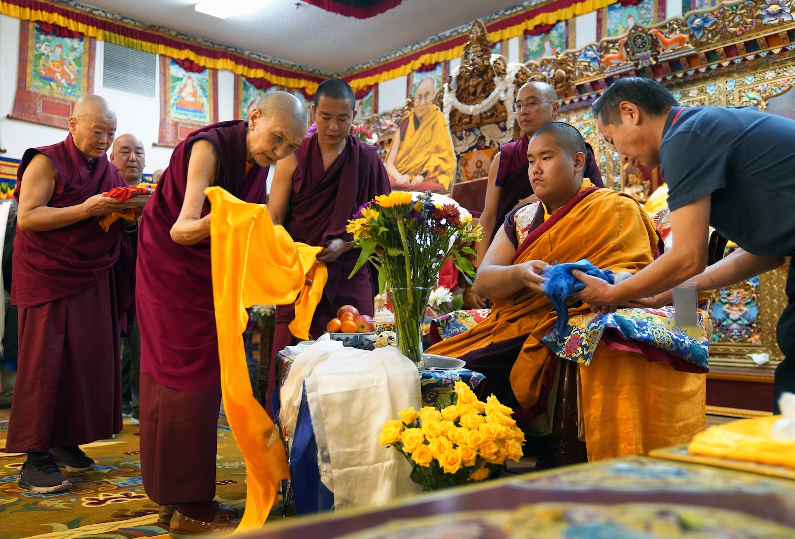 Monks bow and present “khata” to teenage Buddhist lama, Jalue Dorje, at his 18th birthday and enthronement ceremony in Isanti, Minn., on Saturday, Nov. 9, 2024. (AP Photo/Jessie Wardarski)