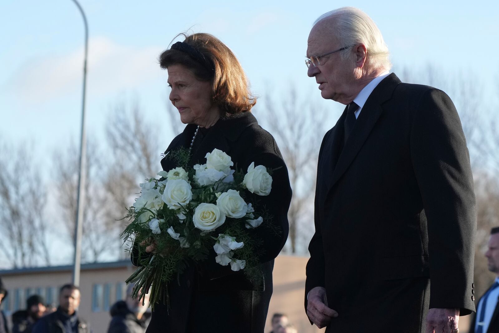 Sweden's King Carl XVI Gustaf and Queen Silvia arrive to place flowers at a memorial near the scene of a shooting on the outskirts of Orebro, Sweden, Wednesday, Feb. 5, 2025. (AP Photo/Sergei Grits)