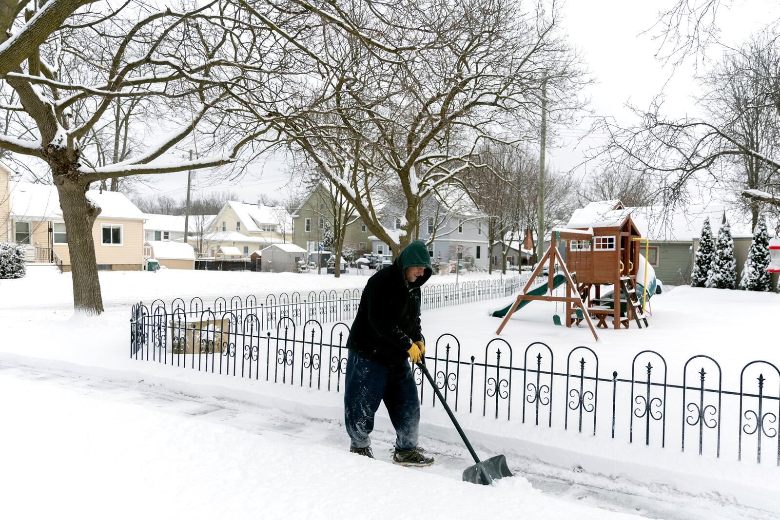 Mike Wildermuth shovels the sidewalk in front of his house on Thursday, Feb. 13, 2025 in Lapeer, Mich. (Jake May/The Flint Journal via AP)