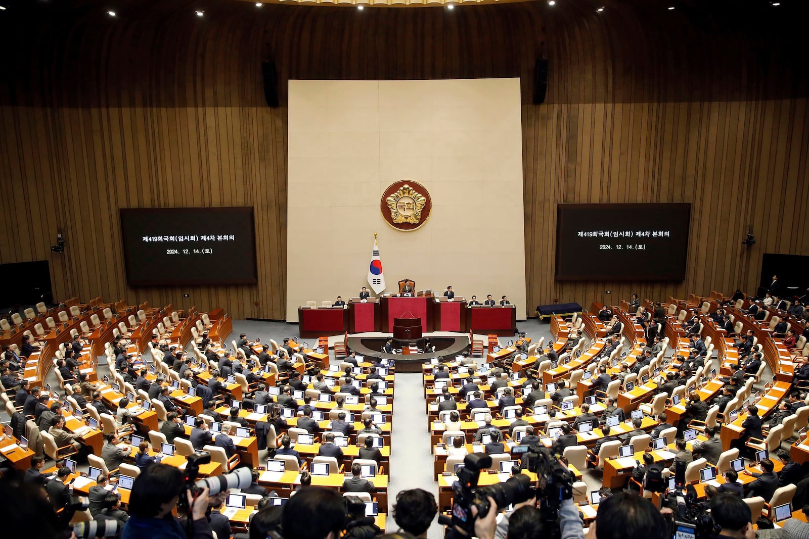 South Korean lawmakers attend plenary session of the impeachment vote of President Yoon Suk Yeol at the National Assembly in Seoul, South Korea, on Saturday, Dec. 14, 2024. (Woohae Cho/Pool Photo via AP)