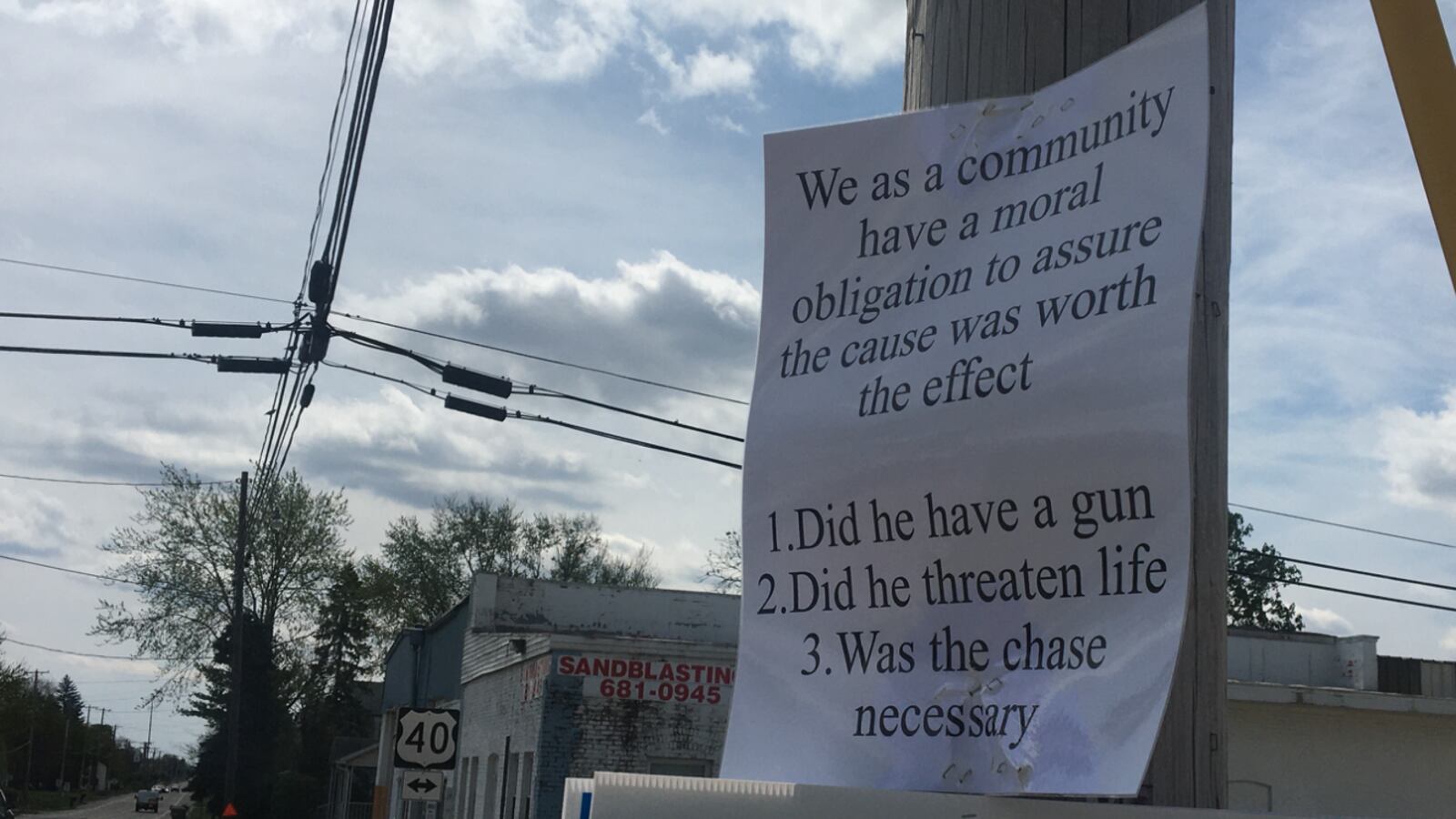 Signs posted at the site of a crash call the community to question whether a police chase that ended in the death of two people was necessary.