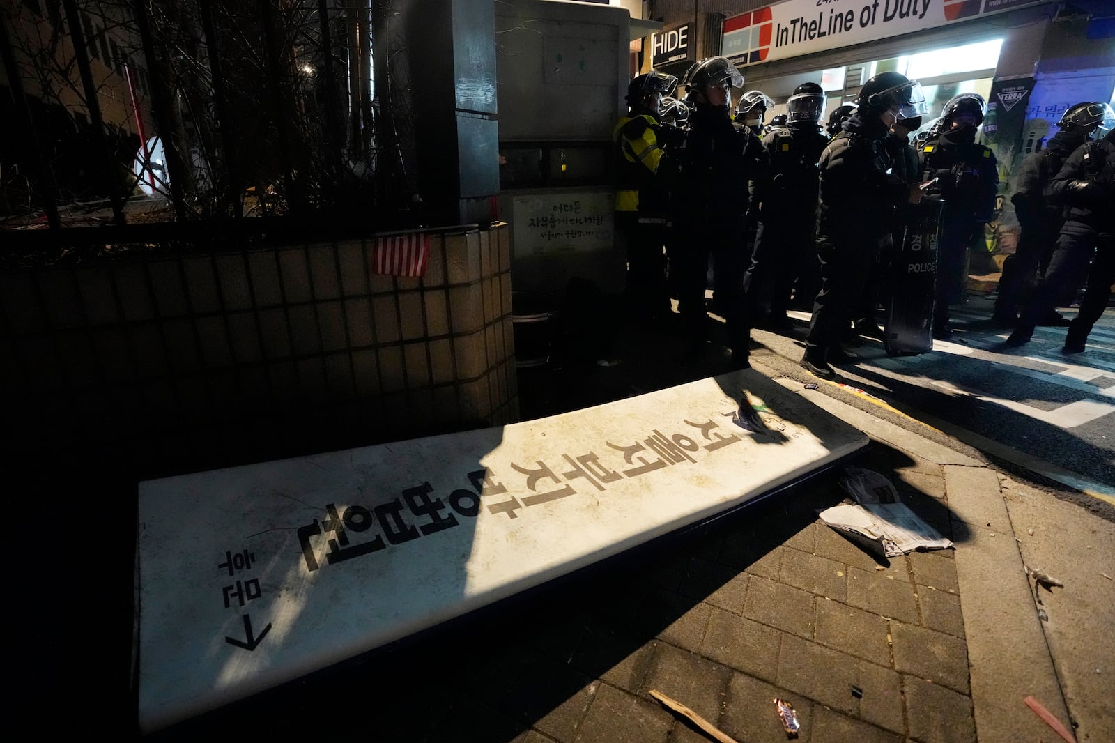 Police officers stand outside of the Seoul Western District Court after supporters of impeached South Korean President Yoon Suk Yeol broke into the court in Seoul, South Korea, Sunday, Jan. 19, 2025. The letters read "The Seoul Western District Court." (AP Photo/Ahn Young-joon)