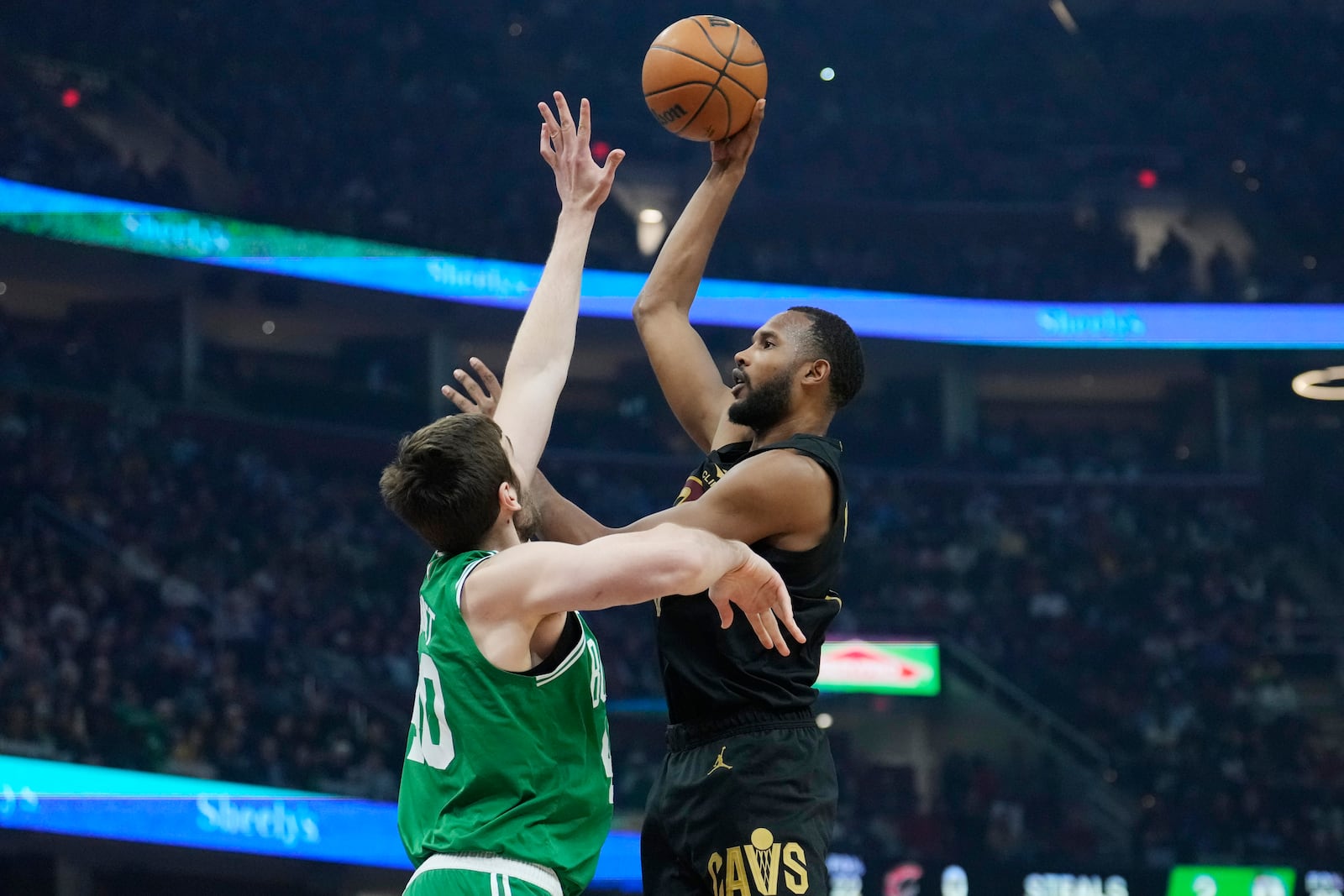 Cleveland Cavaliers forward Evan Mobley, right, shoots over Boston Celtics center Luke Kornet, left, in the first half of an NBA basketball game, Tuesday, Feb. 4, 2025, in Cleveland. (AP Photo/Sue Ogrocki)