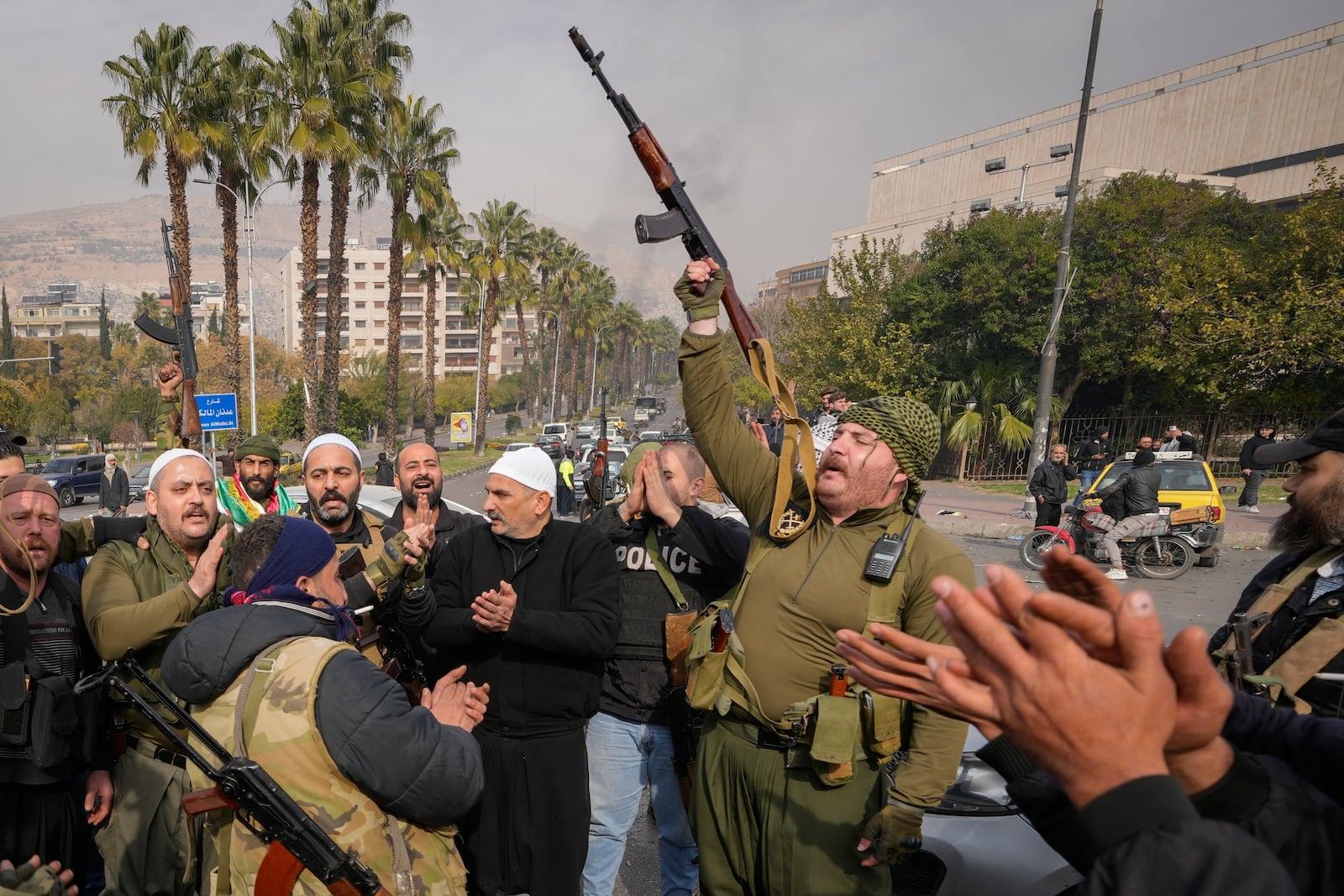 FILE - Opposition fighters celebrate the takeover of the city by the insurgents in Damascus, Syria, Sunday, Dec. 8, 2024. (AP Photo/Hussein Malla, File)