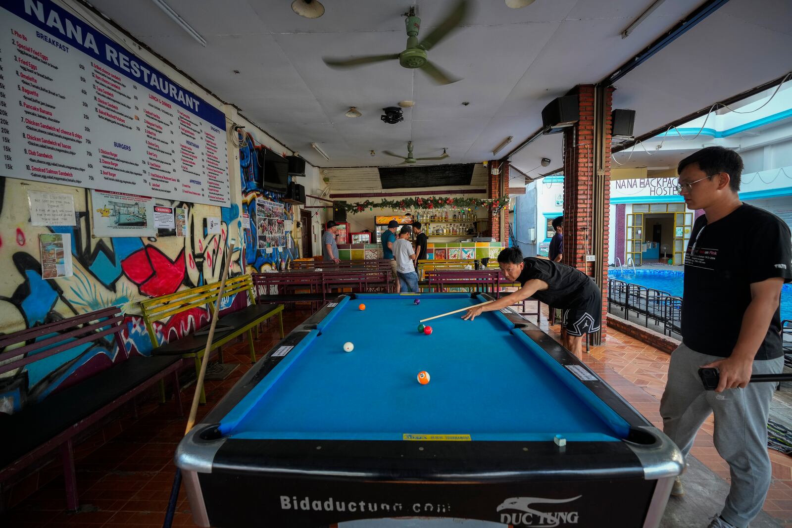 A man plays pool at Nana Backpack hostel in Vang Vieng, Laos, Tuesday, Nov. 19, 2024. (AP Photo/Anupam Nath)